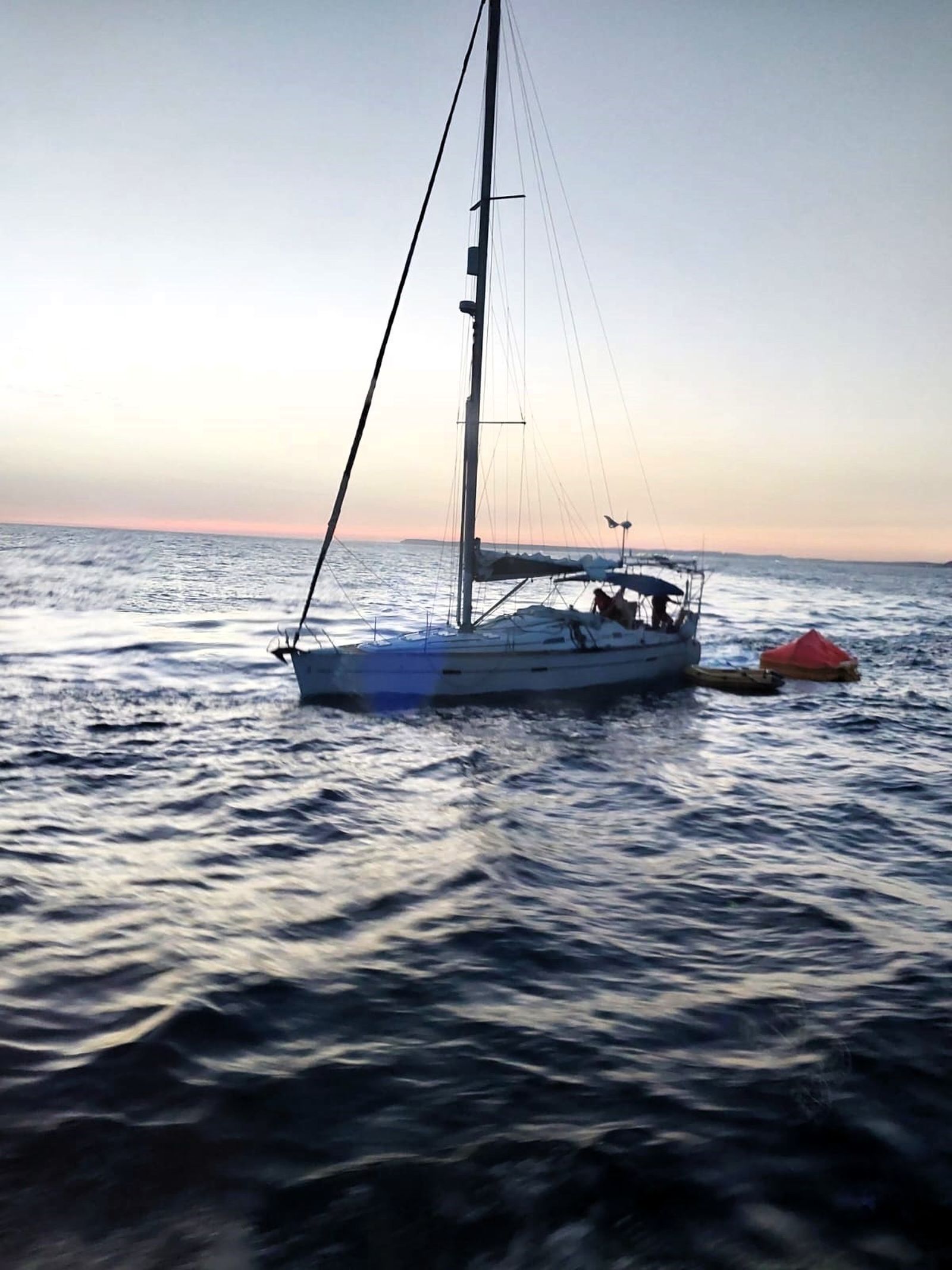 Imagen del velero en aguas del Estrecho con la balsa salvavidas desplegada