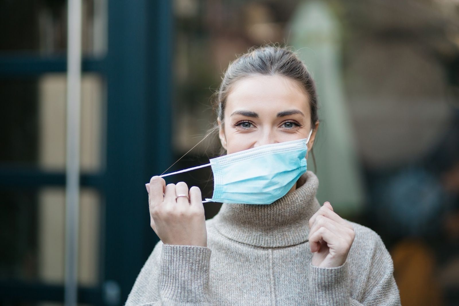 Mujer quitándose la mascarilla.