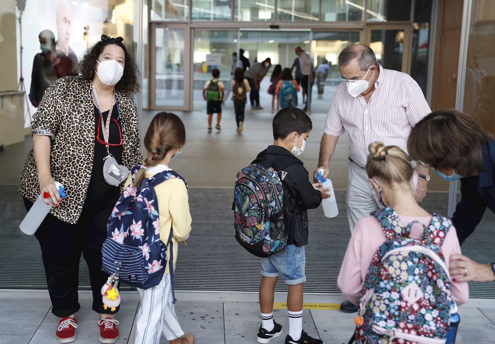 Niños se desinfectan las manos al entrar a un colegio