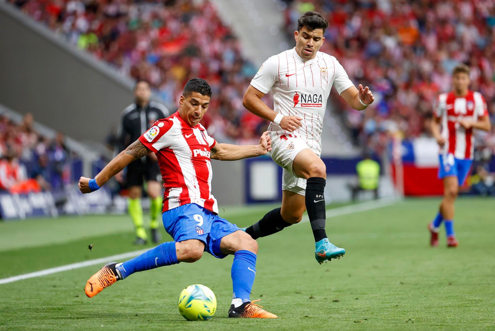 Luis Suárez disputa un valón con el sevillista Acuña