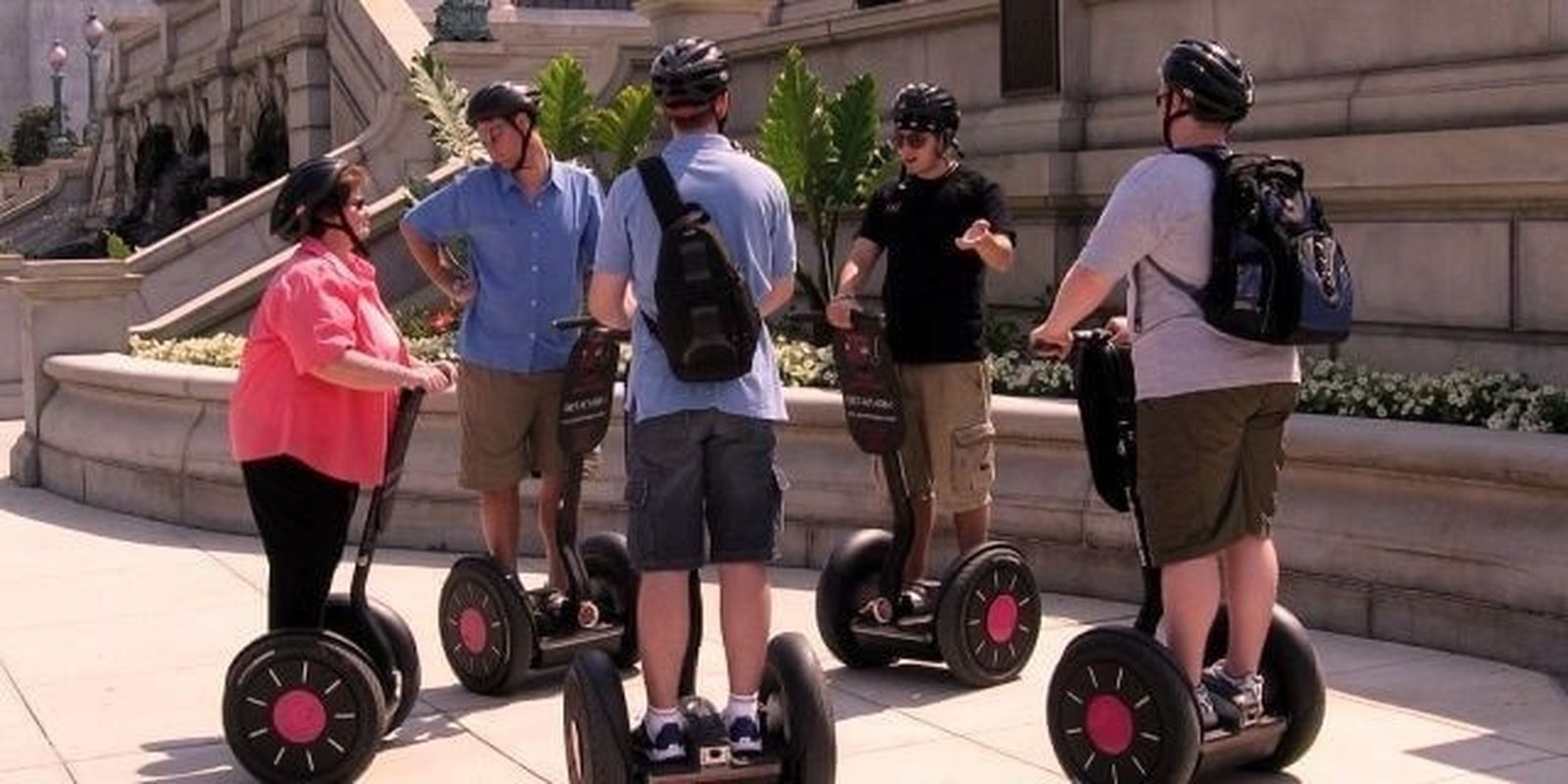 Un grupo de turistas con vehículos eléctricos individuales sobre una acera