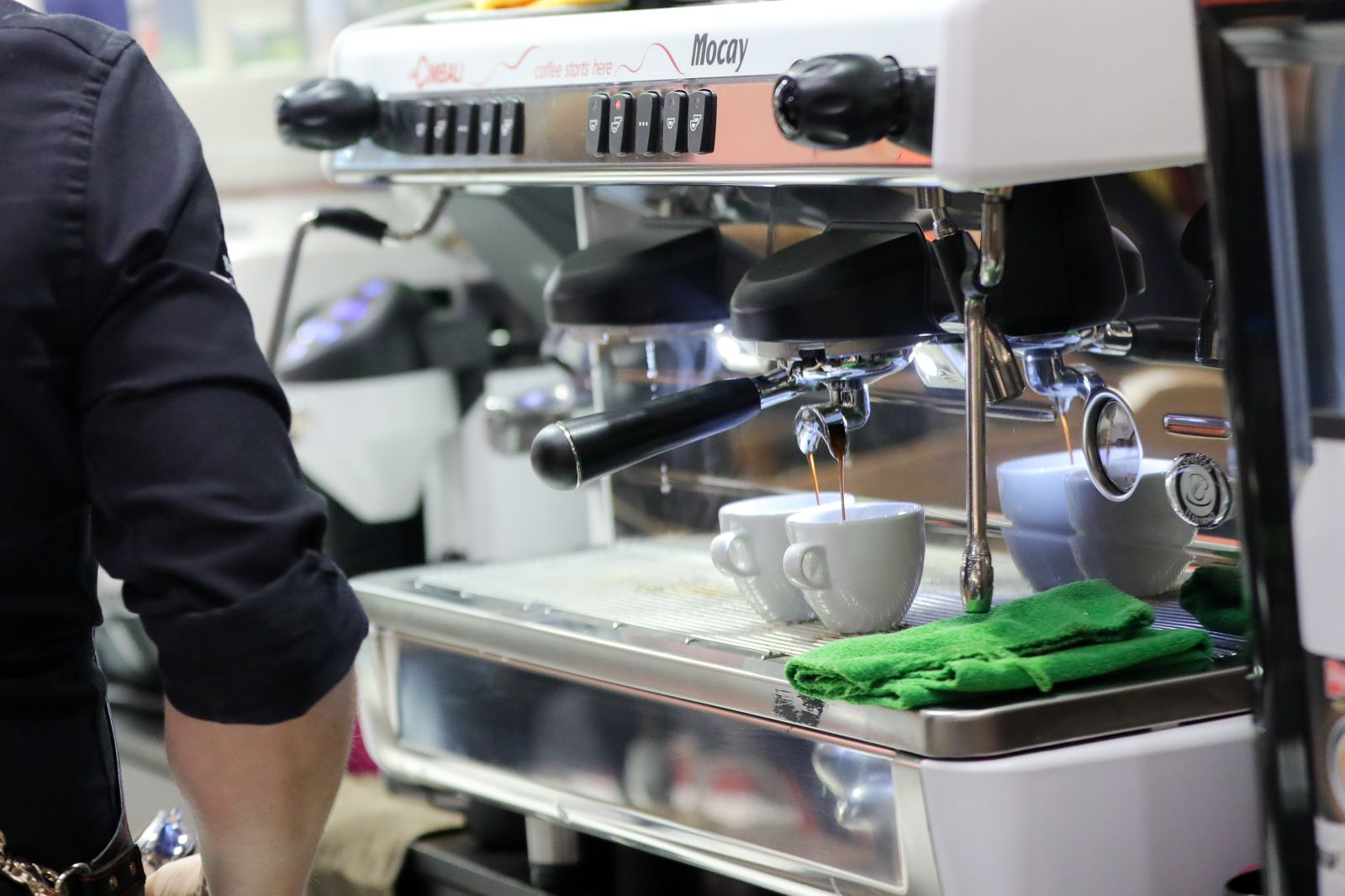 Un camarero prepara café e un bar de Madrid