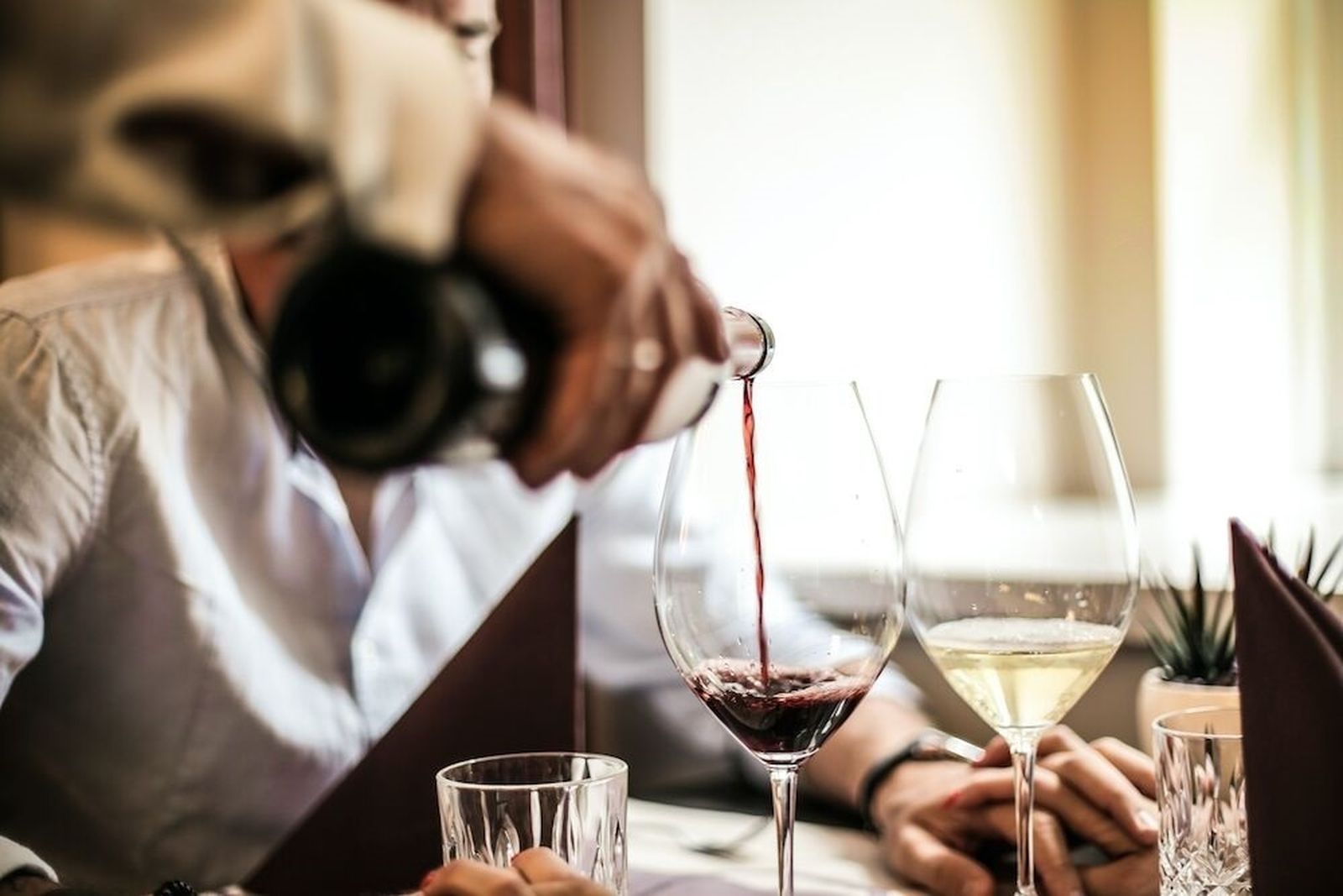 Un camarero sirve vino en una copa.