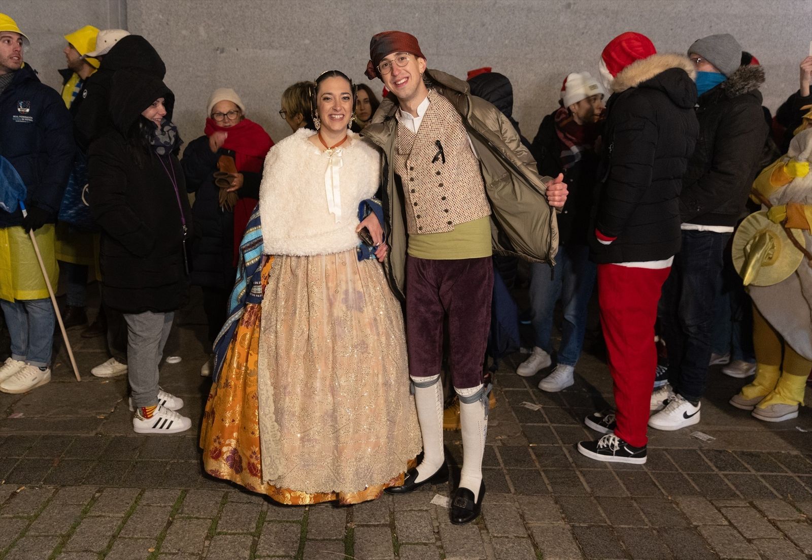 Una pareja vestidos de falleros ante las puertas del Teatro Real