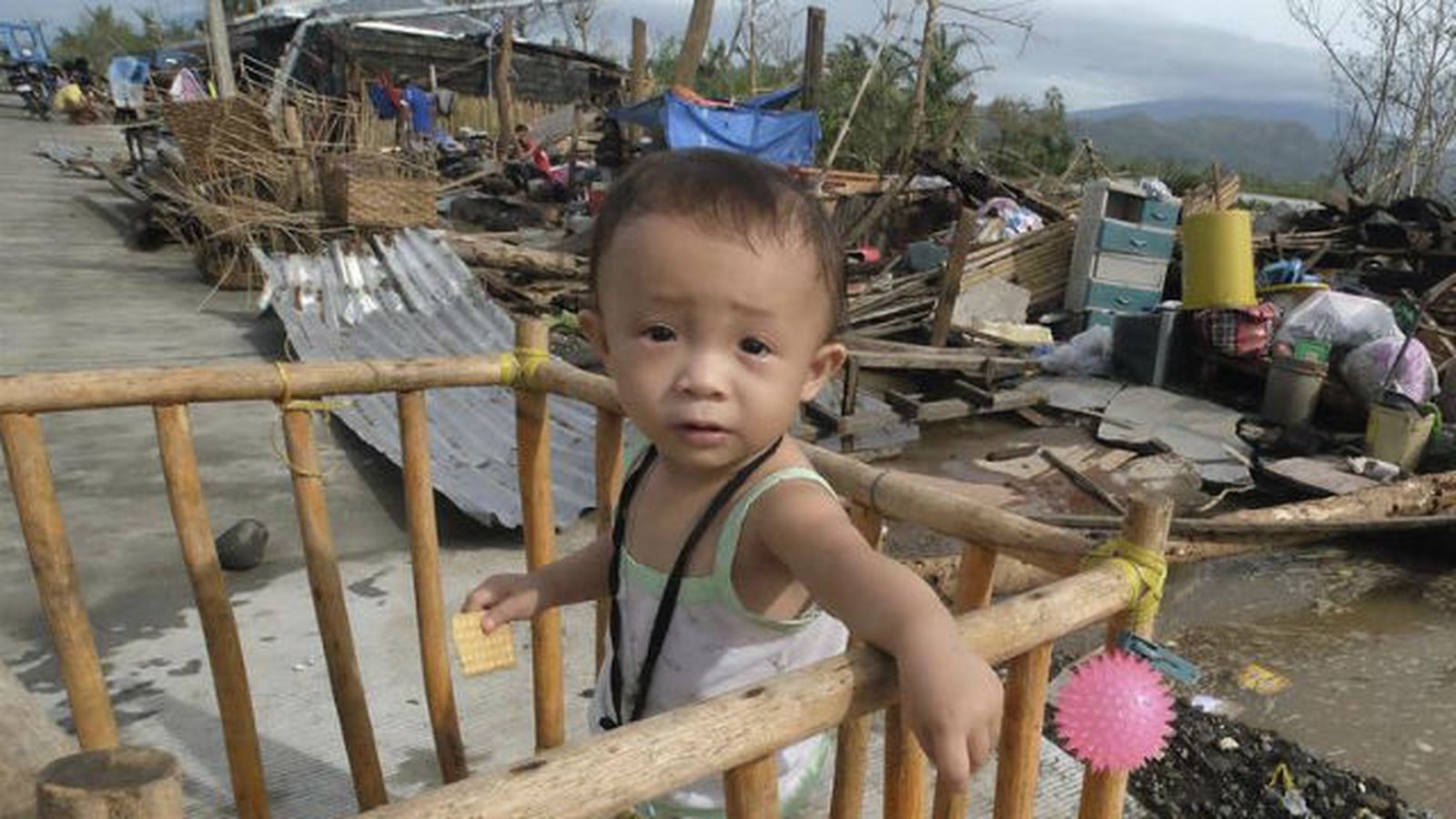 Un niño descansa entre los escombros de las casas dañadas por el paso del tifón Nock-Ten por la localidad de Polangui, provinc