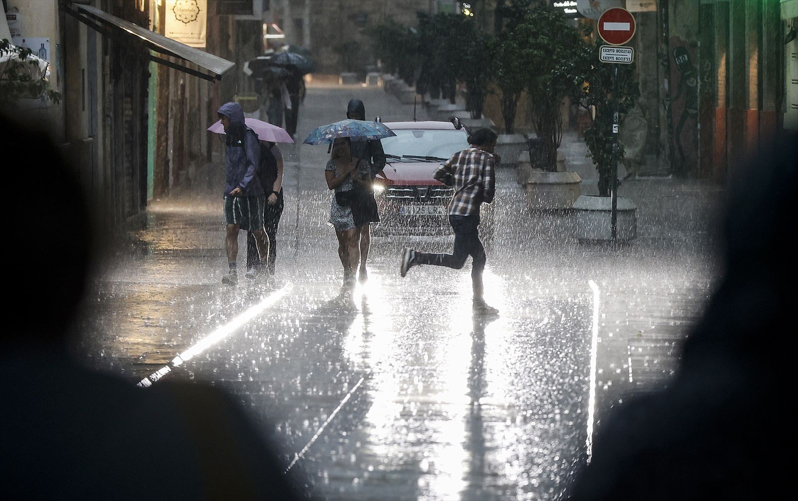 Varias personas caminan bajo la lluvia