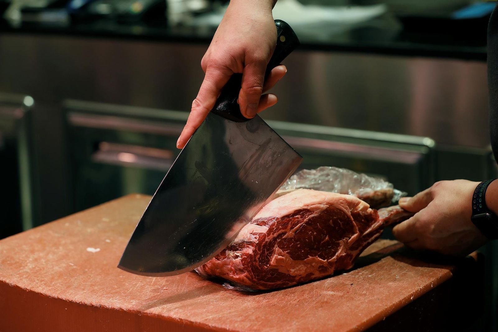 Un carnicero trabaja con una pieza de carne