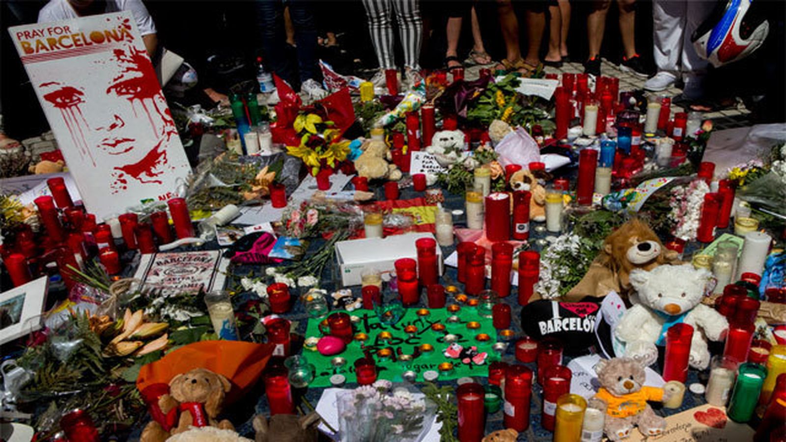 Velas y flores que miles de personas han colocado en Las Ramblas