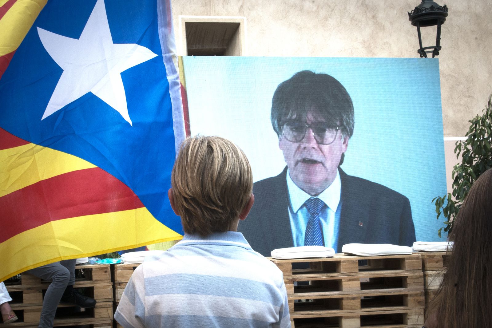 Un niño observa la intervención telemática de Carles Puigdemont