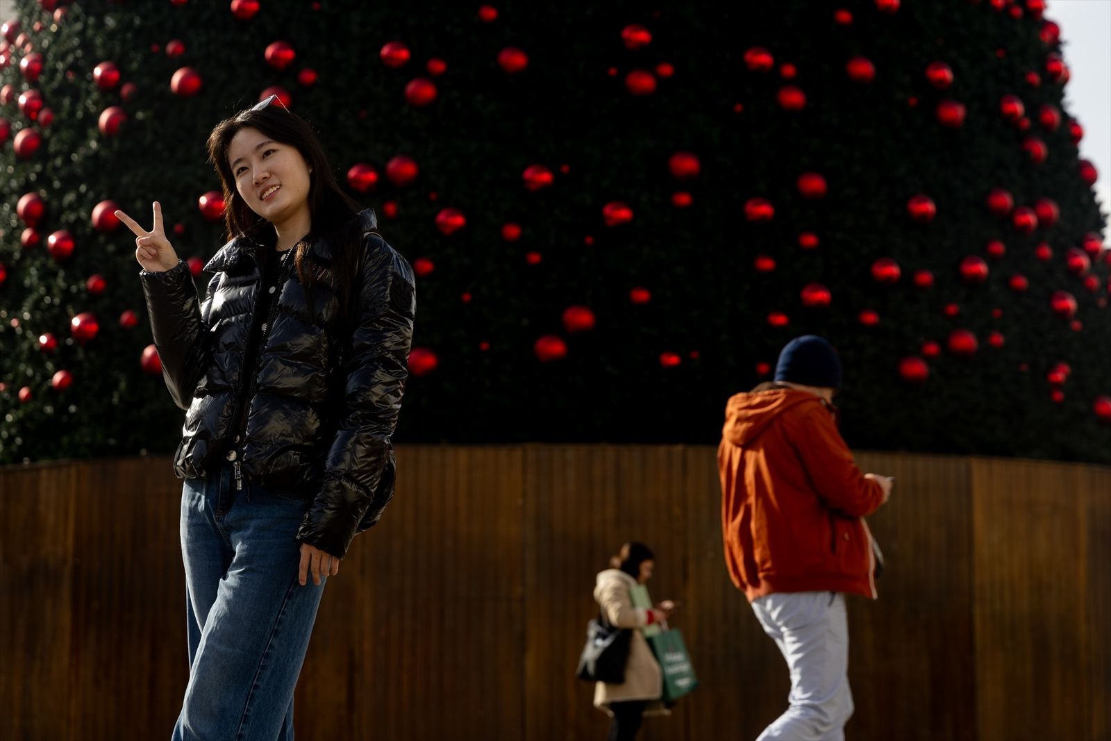 Una turista se hace una foto junto al árbol de Navidad de la Puerta del Sol,