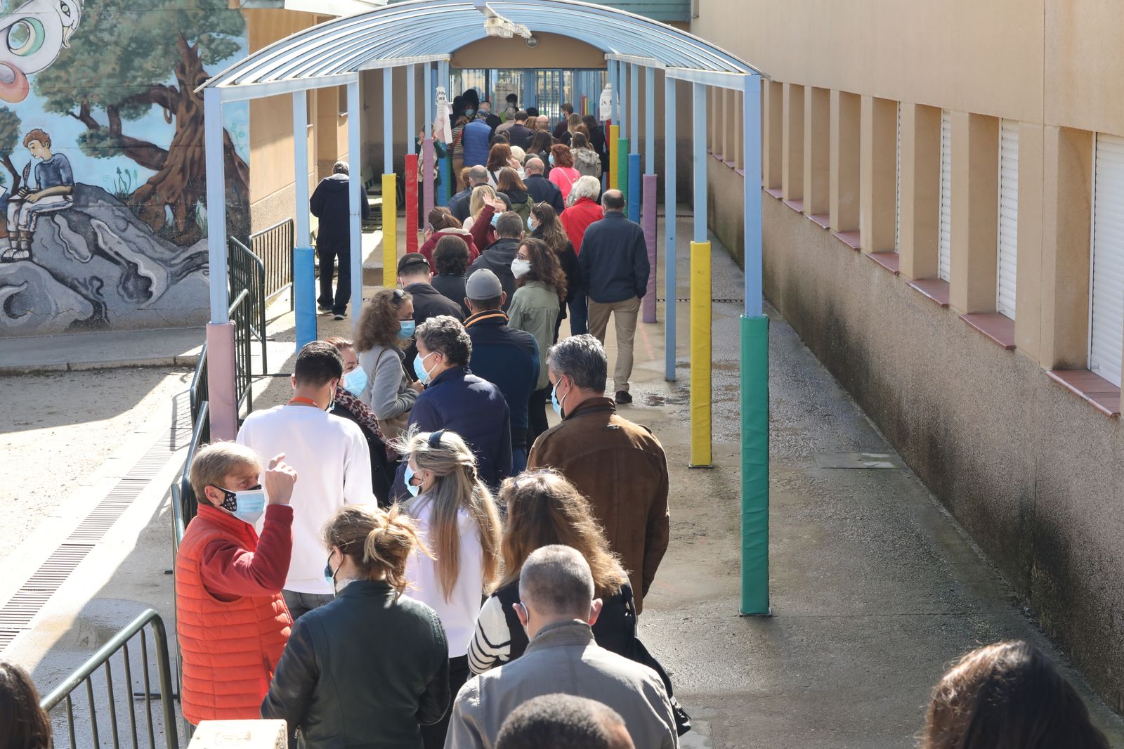 Fila de personas esperando para acceder al colegio electoral y poder votar
