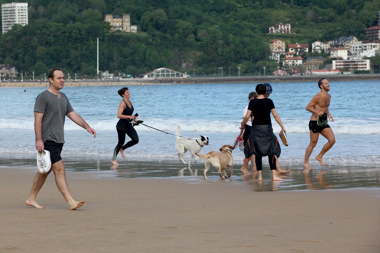 Varias personas pasean por la playa de La Concha en San Sebastián