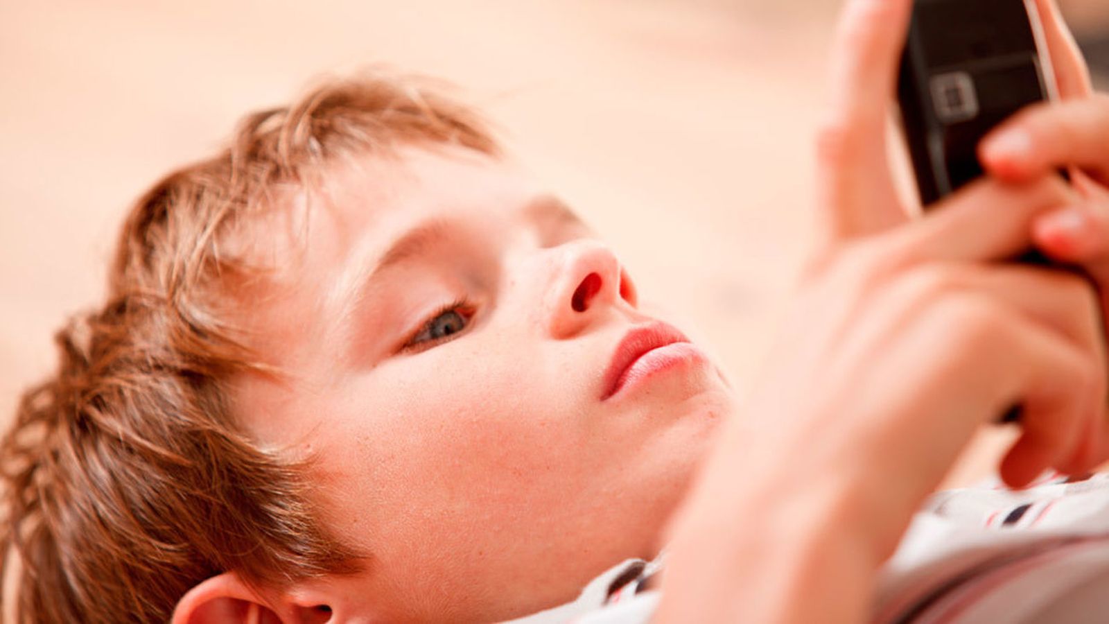 Un niño utiliza un teléfono móvil
