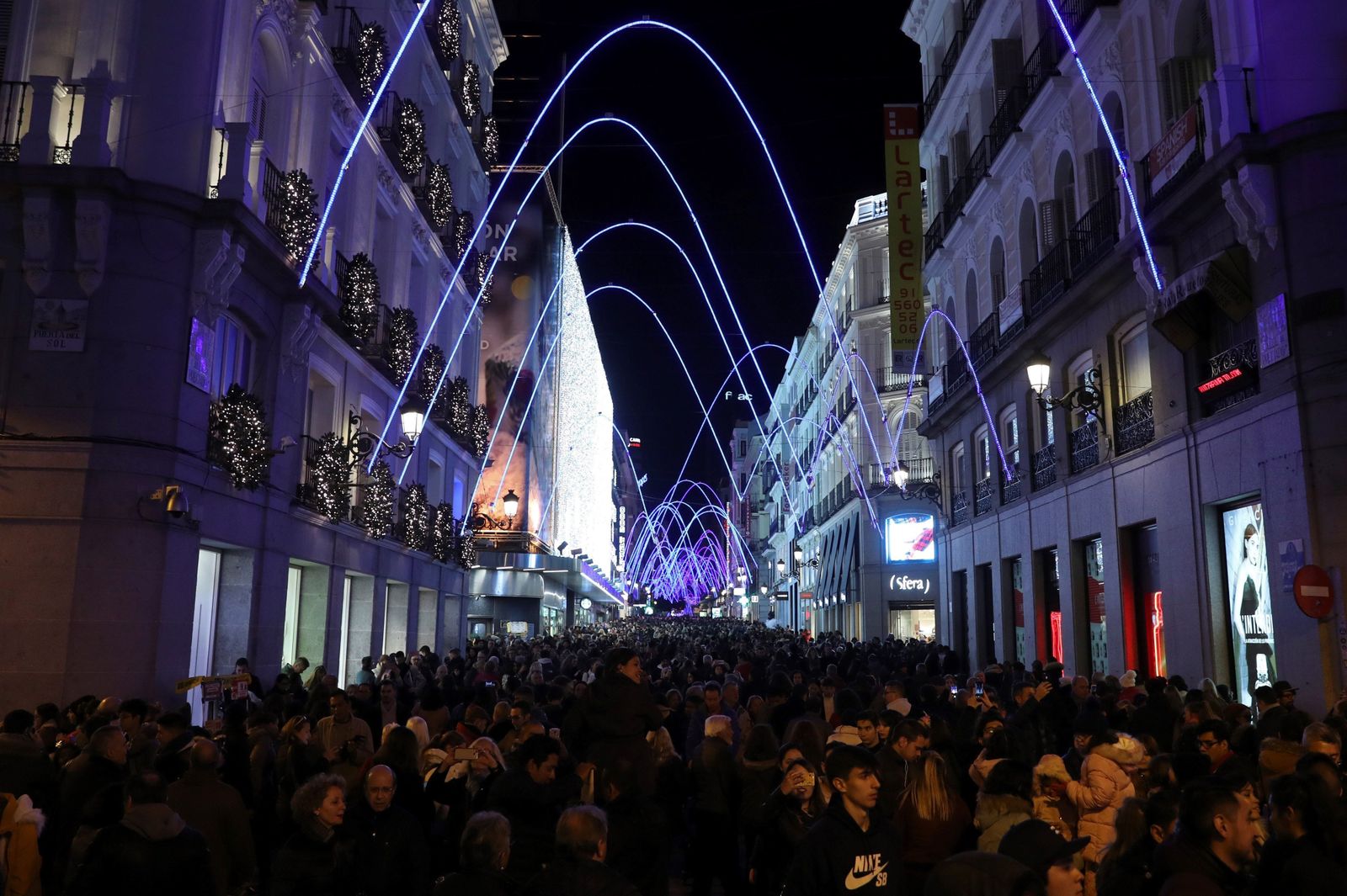 Personas paseando por  la calle Preciados de Madrid, durante el tradicional encendido de luces de Navidad. (EFE)