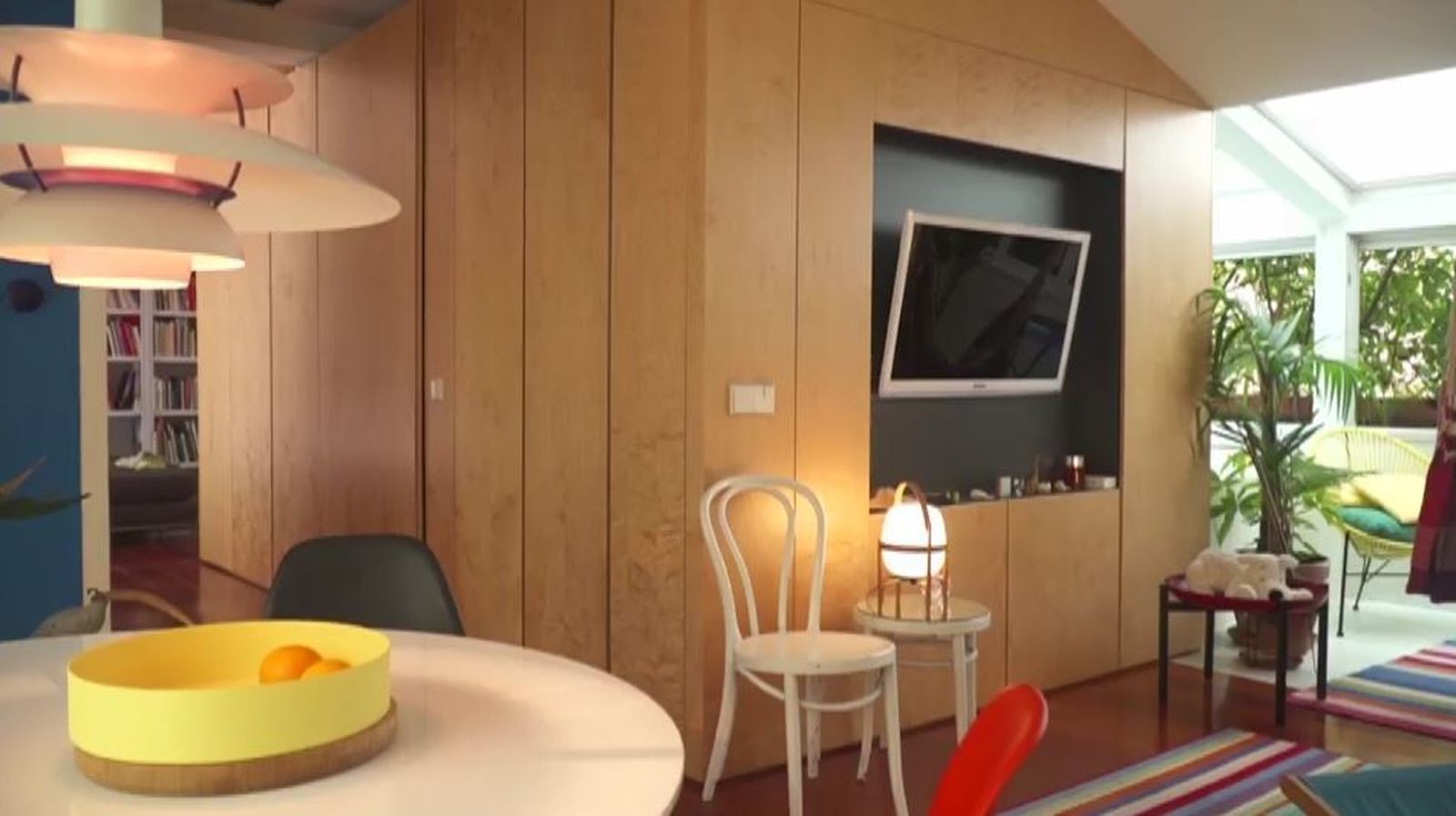 Este 'cubo' de madera que muestra el televisor, es en realidad un centro de almacenaje tras el que se esconde, además, el cuarto de baño.