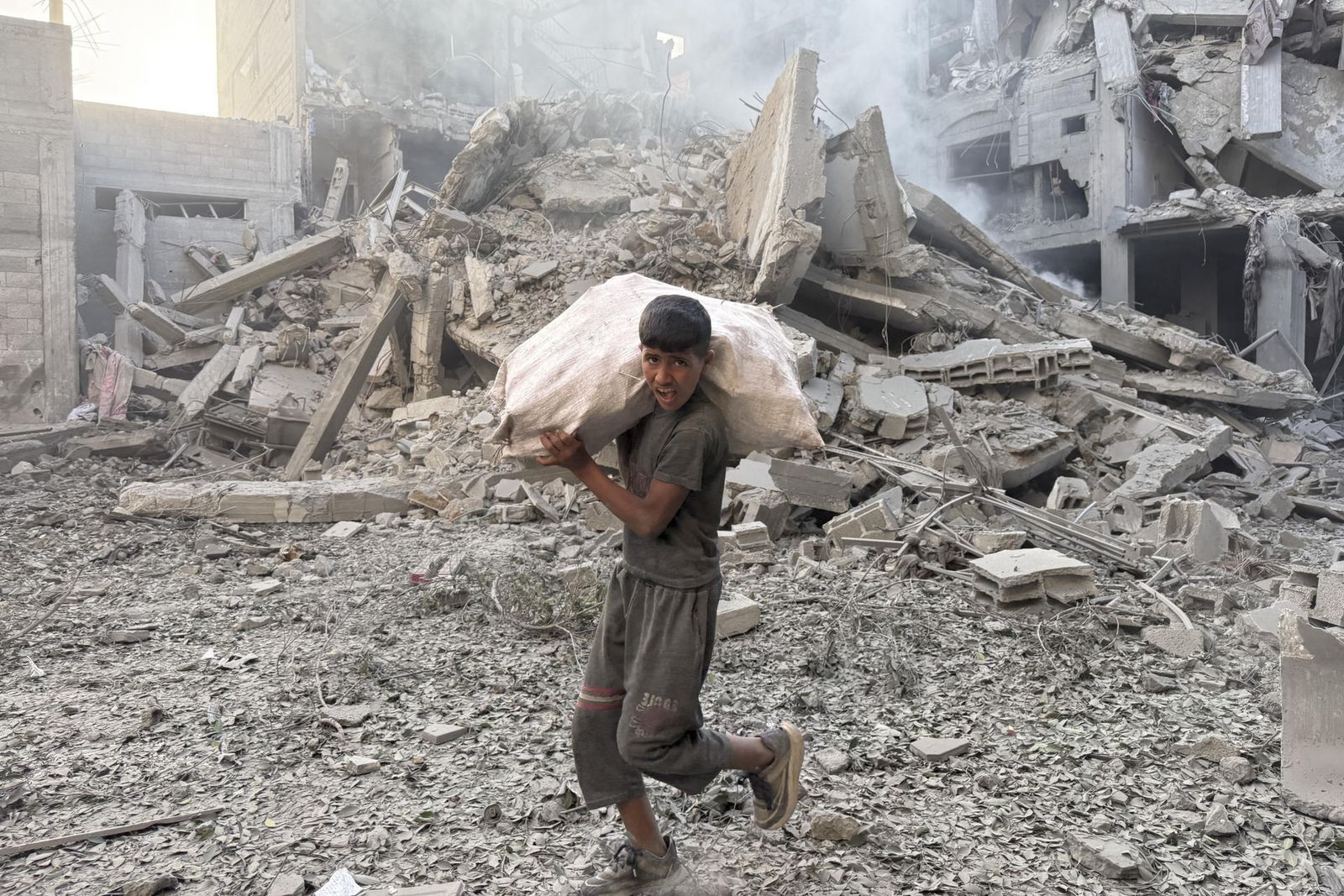 Un niño camina entre escombros en Gaza