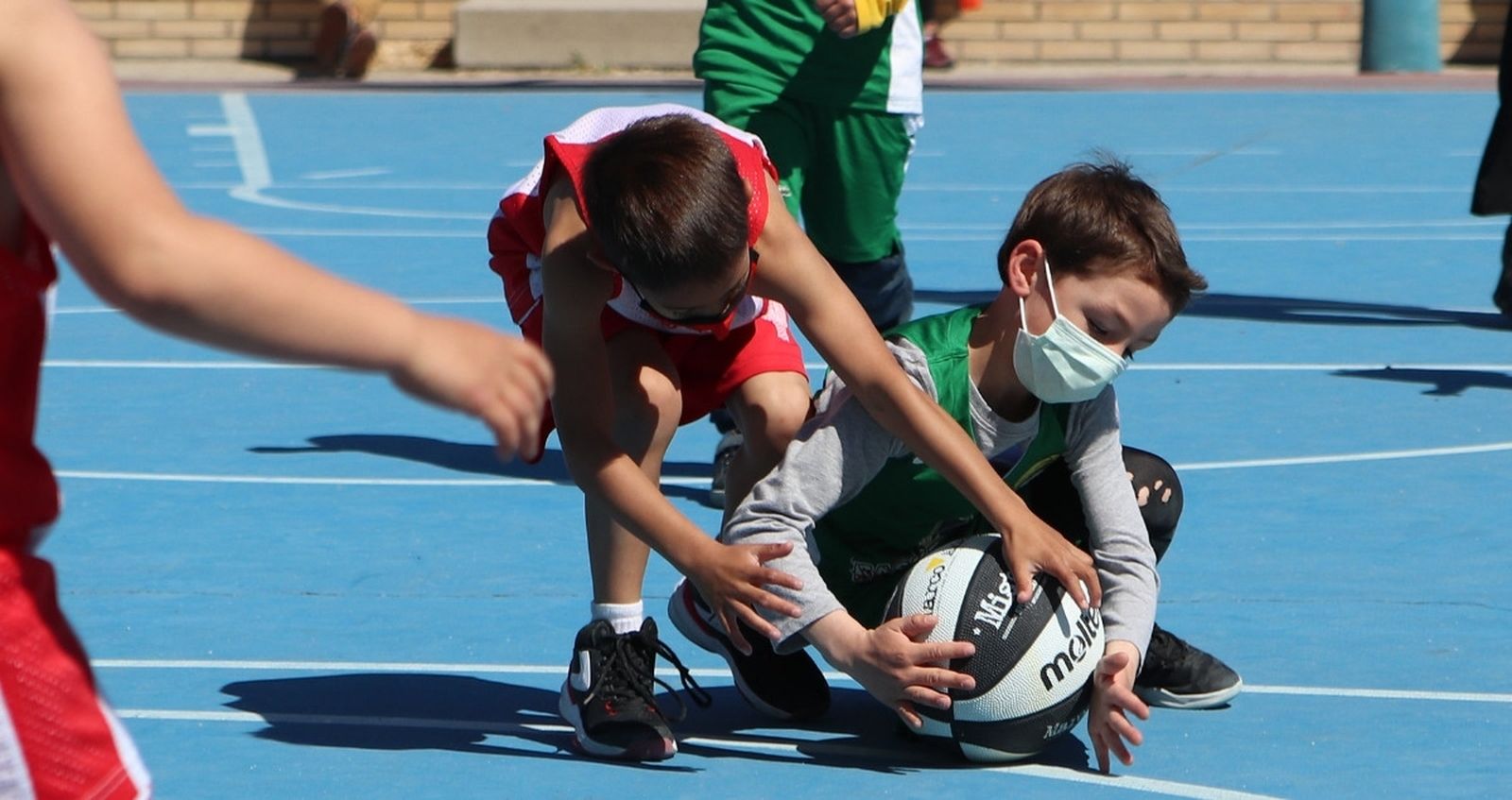 Lucha por el balón en un encuentro de baloncesto infantil