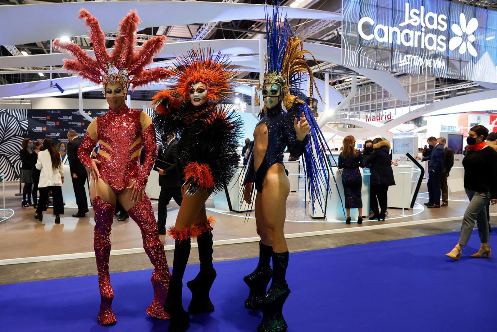 Varias drag queens posan delante del estand de las Islas Canarias