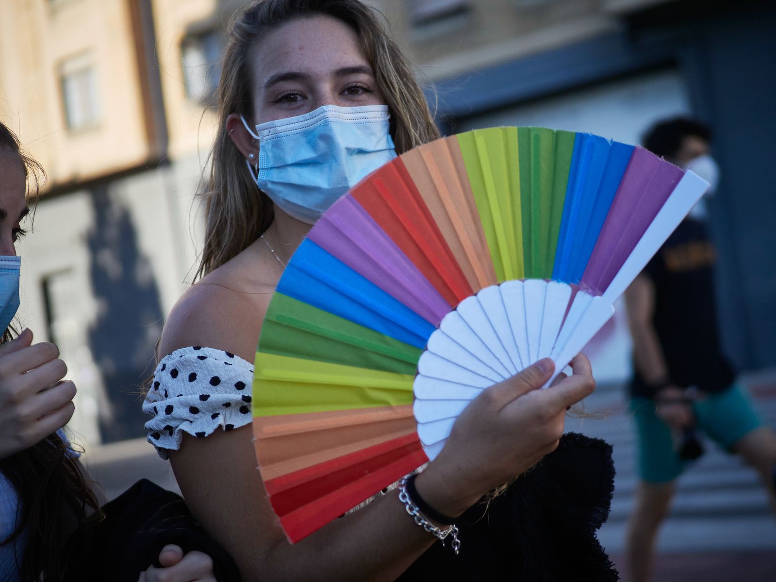 Una joven celebra el Orgullo con un abanico arcoiris
