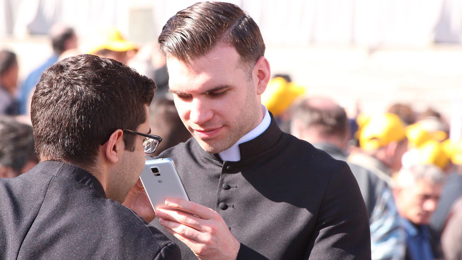 Un sacerdote consulta su teléfono móvil