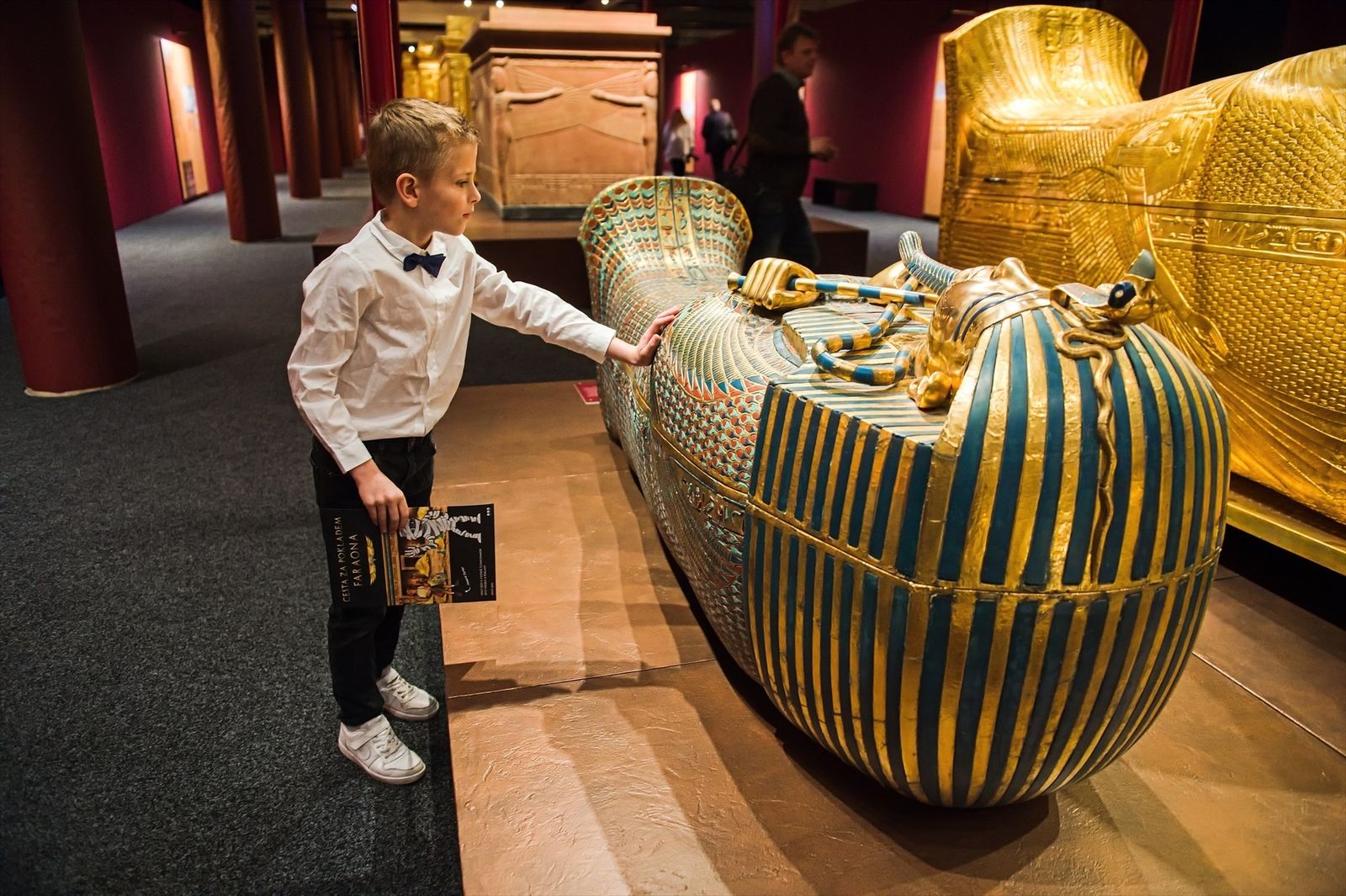 Un niño toca el ataúd dorado del rey Tutankamón durante una gira de prensa para la exposición "Tutankamón: su tumba y sus tesoros"