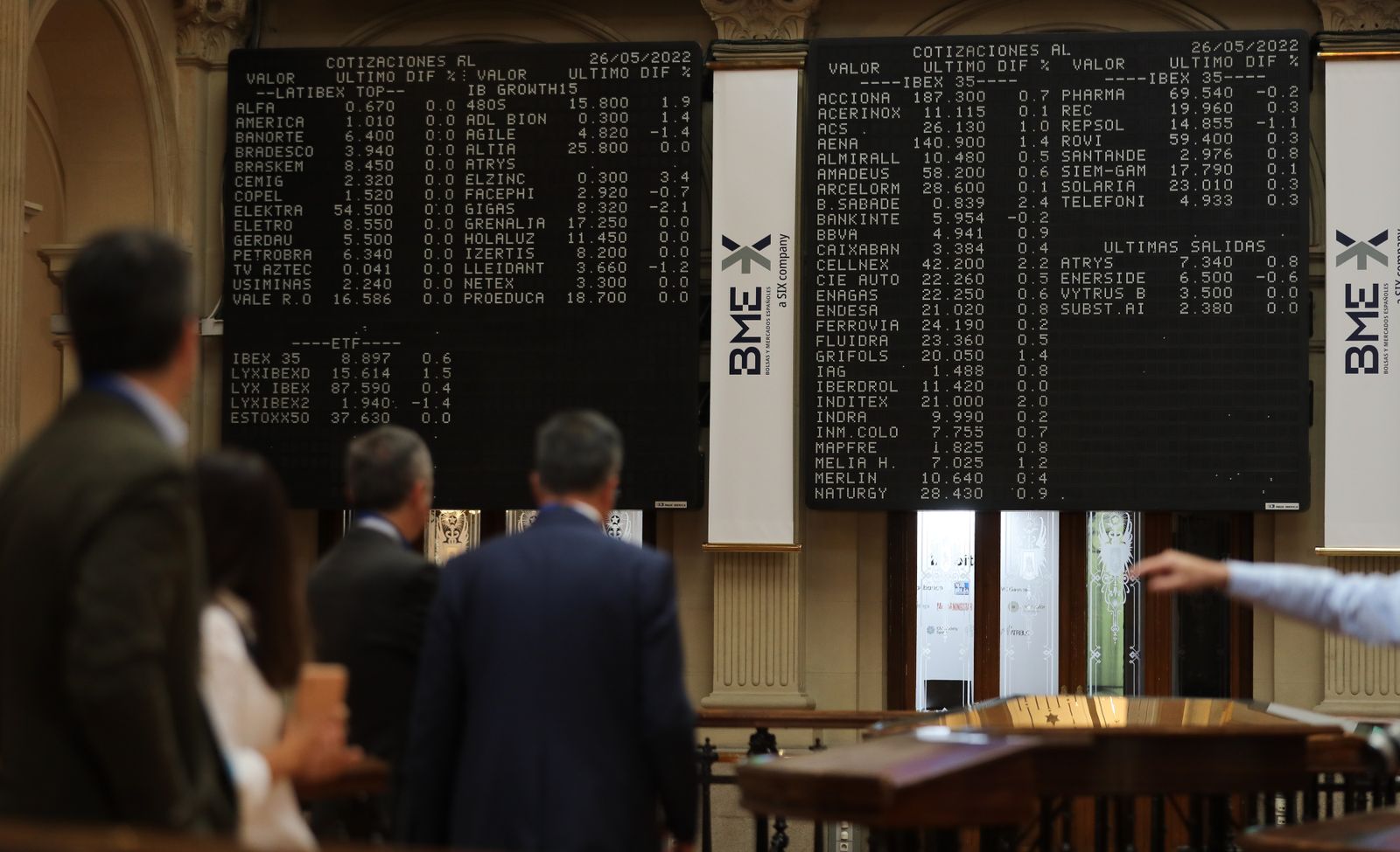 Varias personas frente a los paneles de valores del IBEX 35