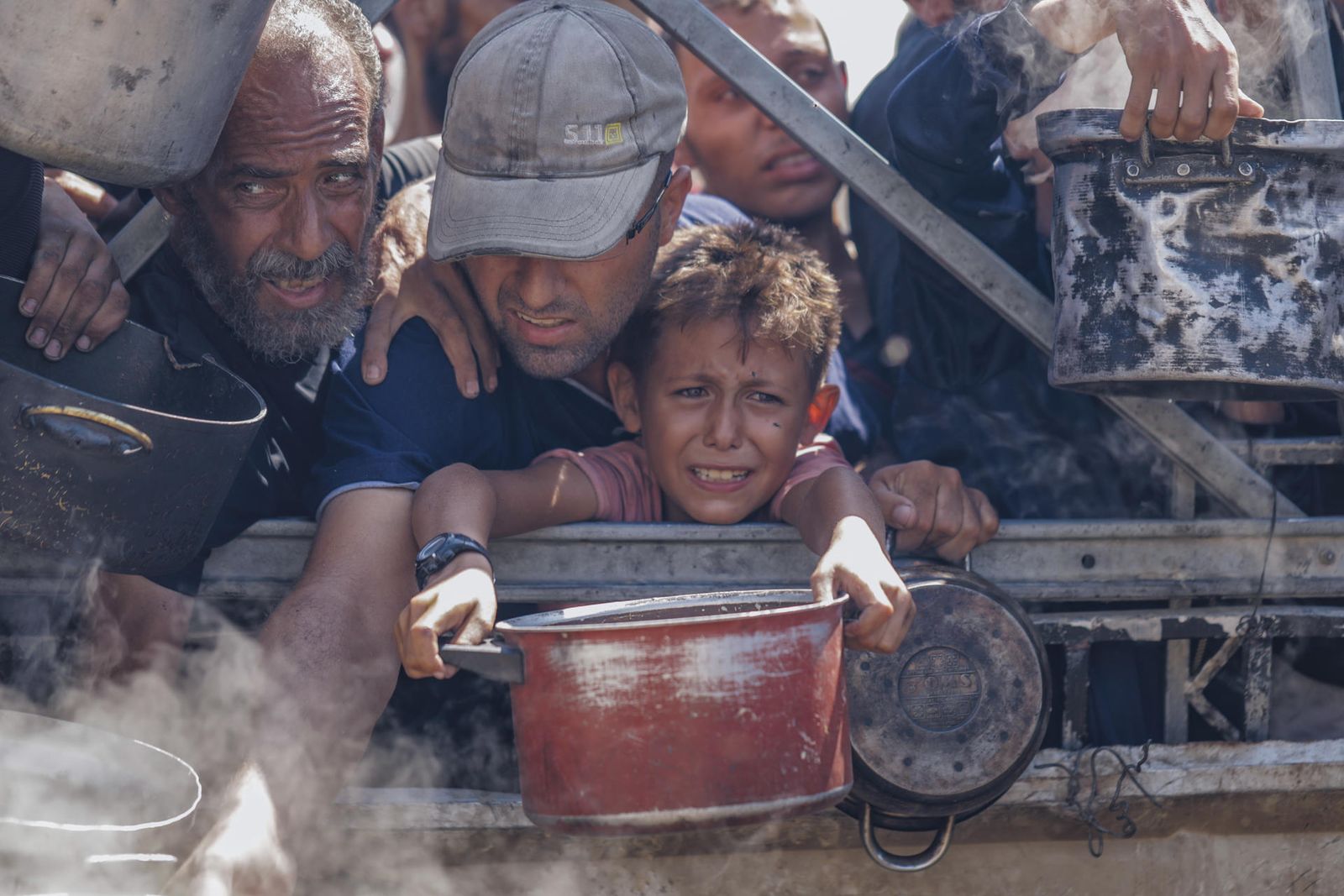 Palestinos tratando de conseguir comida en los centros de distribución de ayuda humanitaria