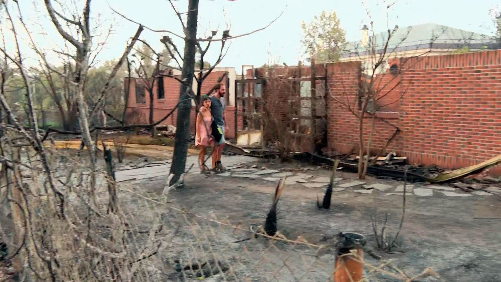 Una pareja pasea el día después del incendio de Tres Cantos que ha asolado 2.000 hectáreas de campo y varias casas y empresas del municipio