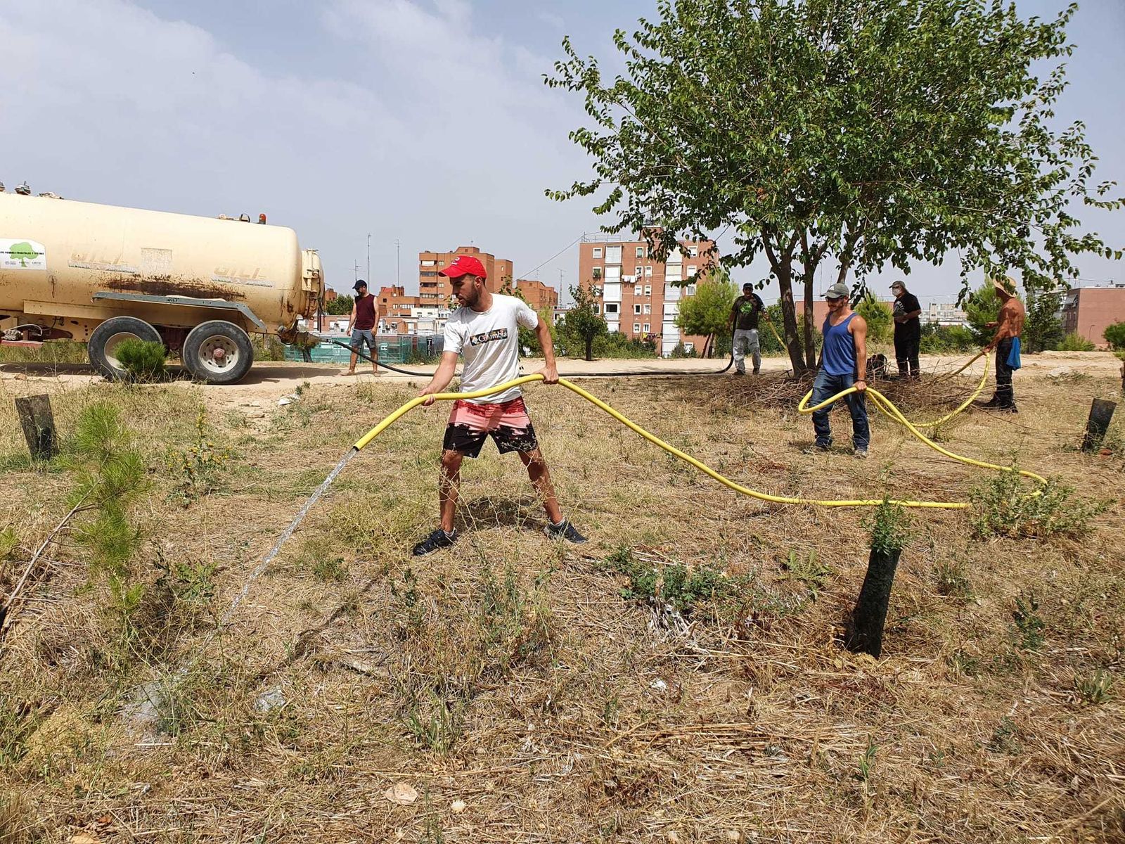 Vecinos de Campamento riegan los árboles en la zona de Colonia Jardín