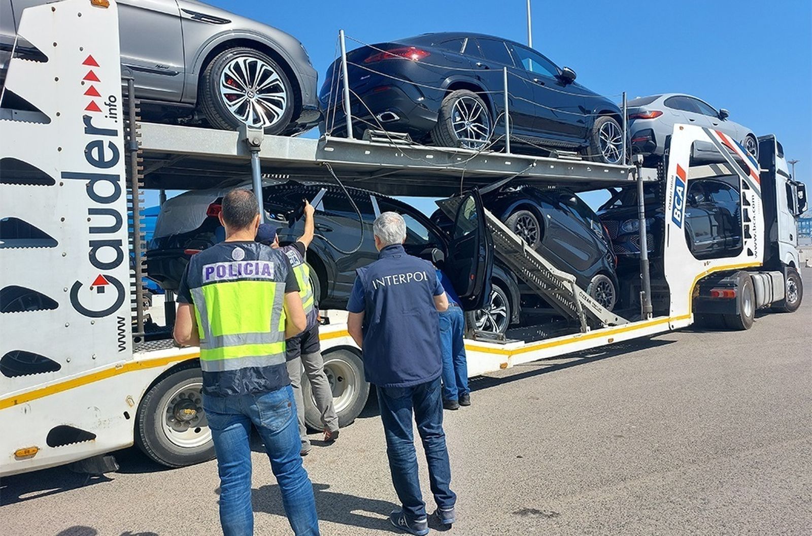 Policías junto a parte de los vehículos recuperados en España
