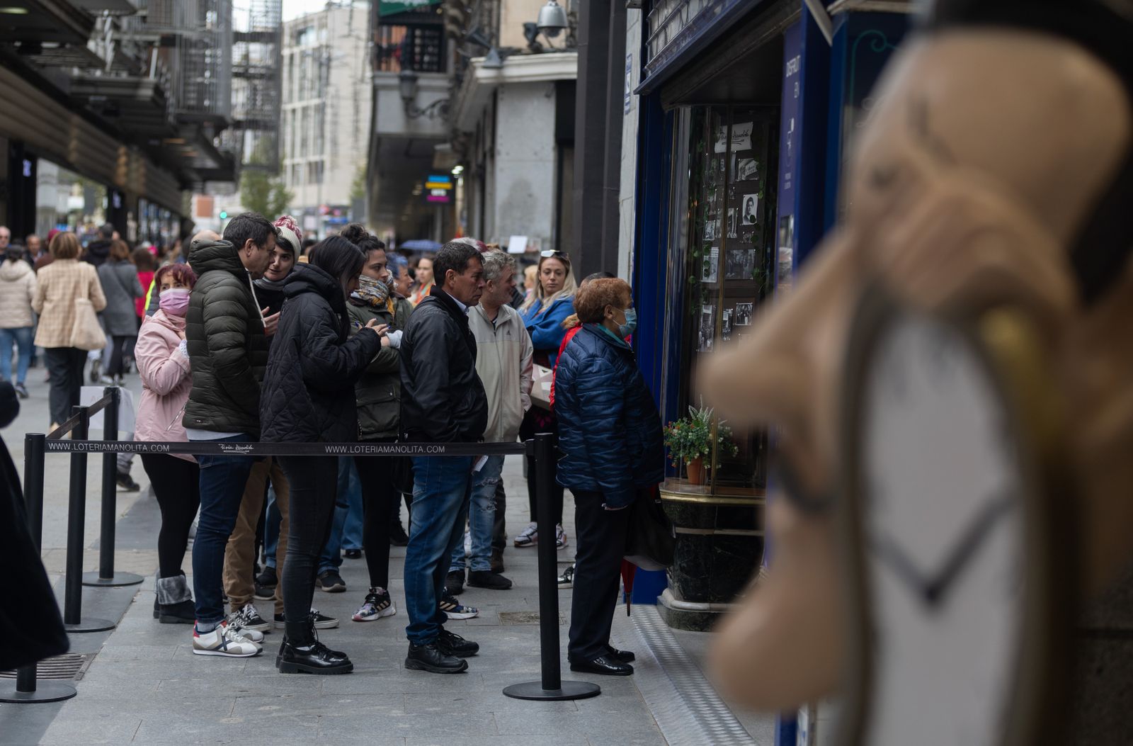 Varias personas en las inmediaciones de la administración de loterías Doña Manolita