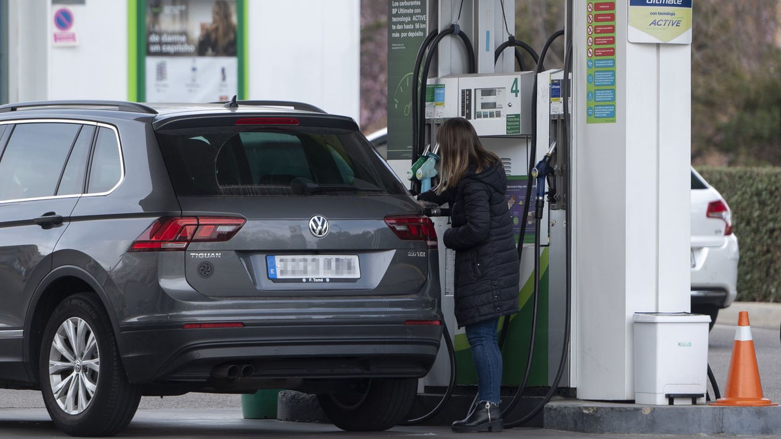 Una mujer reposta en una gasolinera