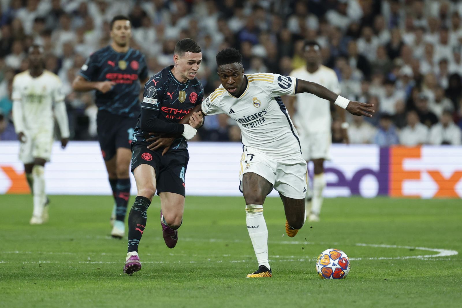 Vinicius Junior protege el balón ante Phil Foden