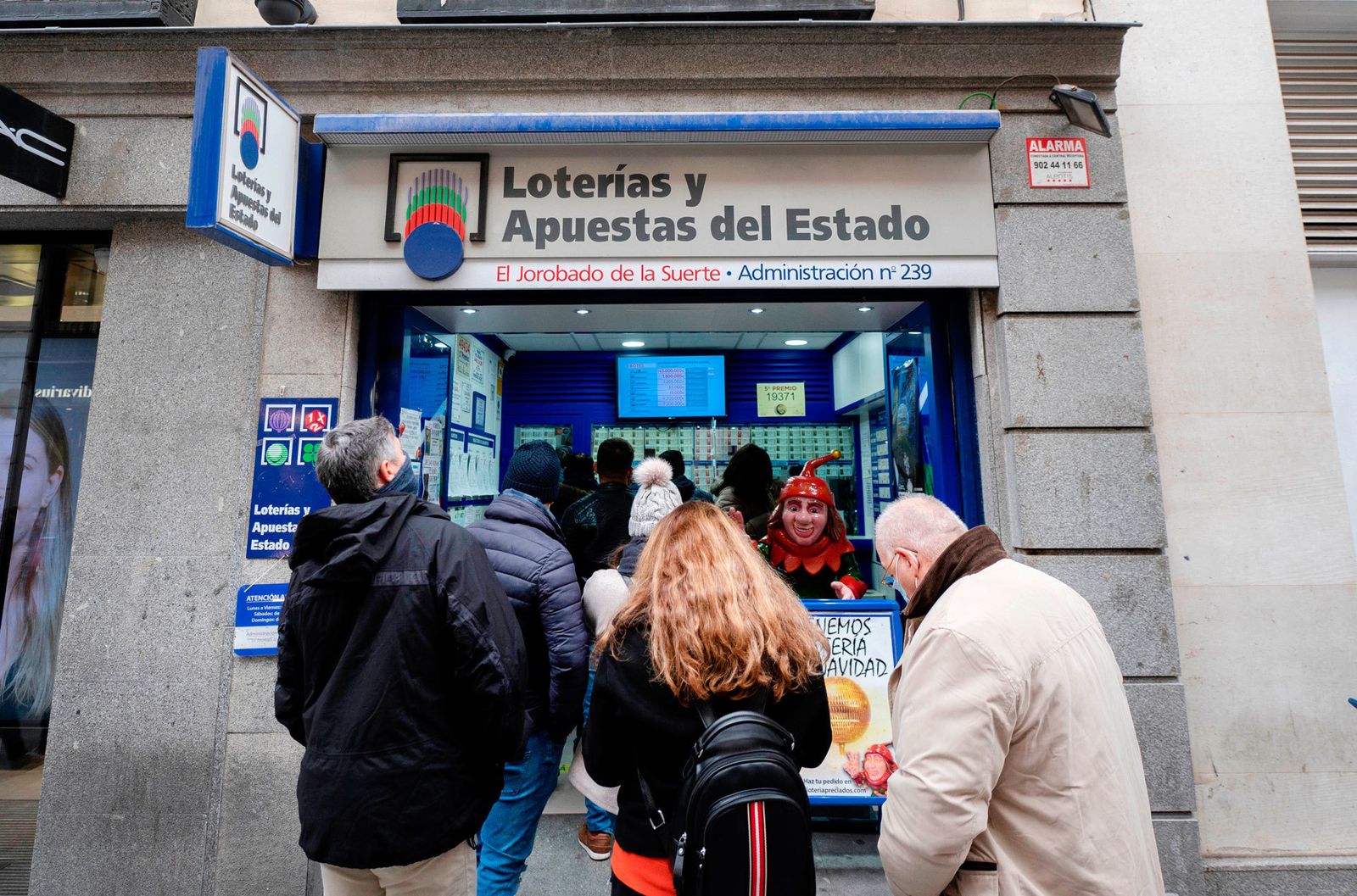 Varias personas hacen cola en la Administración de Loterías 'El jorobado de la suerte', en Madrid