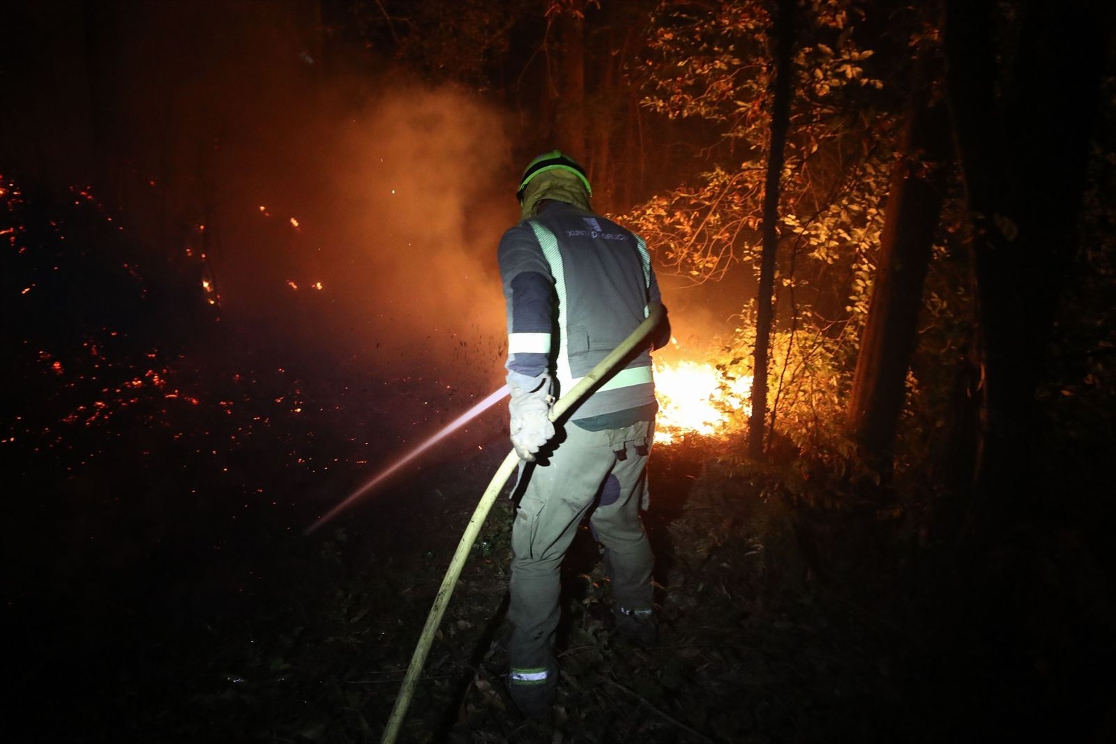 Un bomberos en las labores de extinción de un incendio en Barreiros