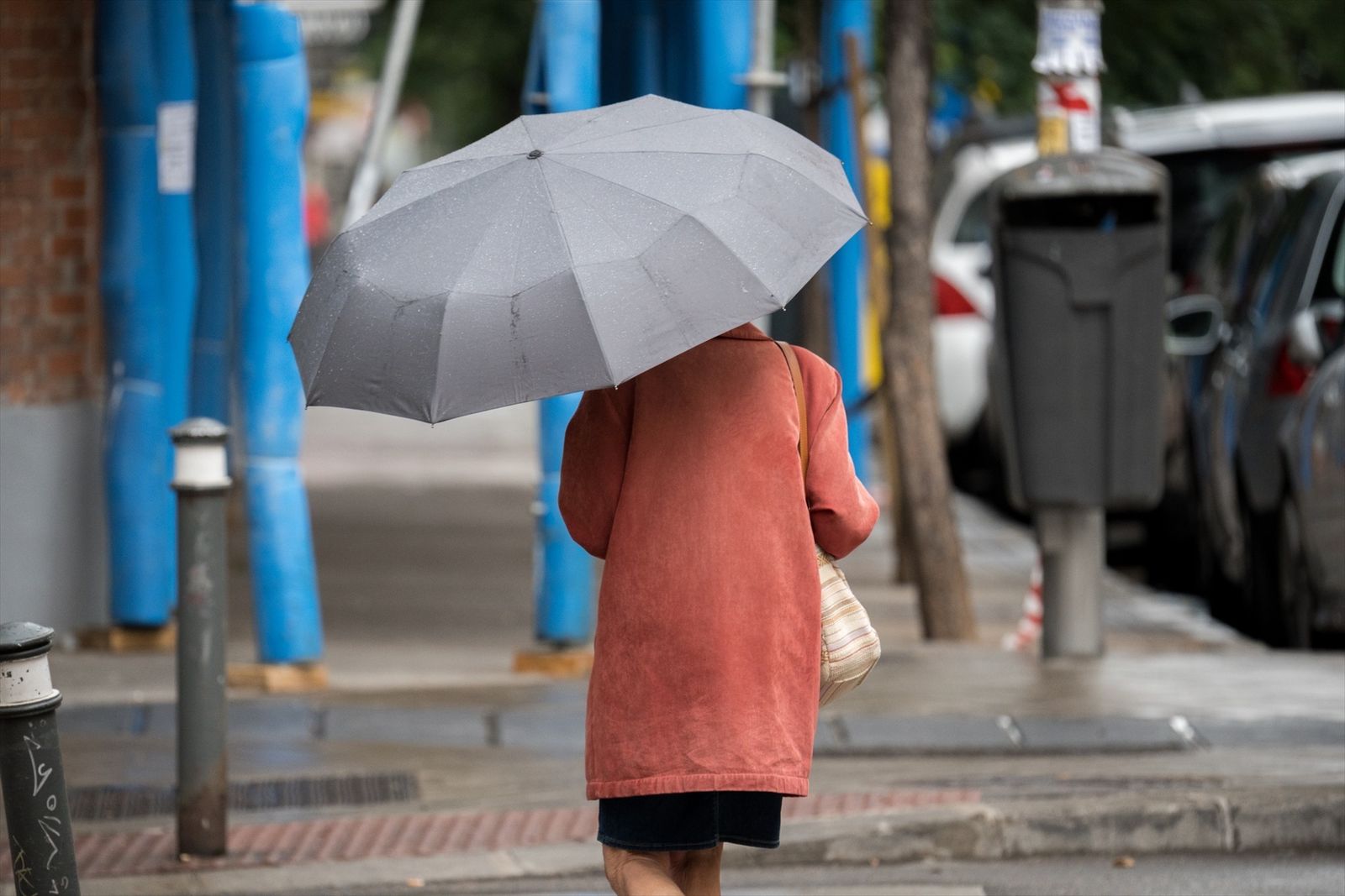 Una mujer pasea con un paraguas para protegerse de la lluvia en Madrid