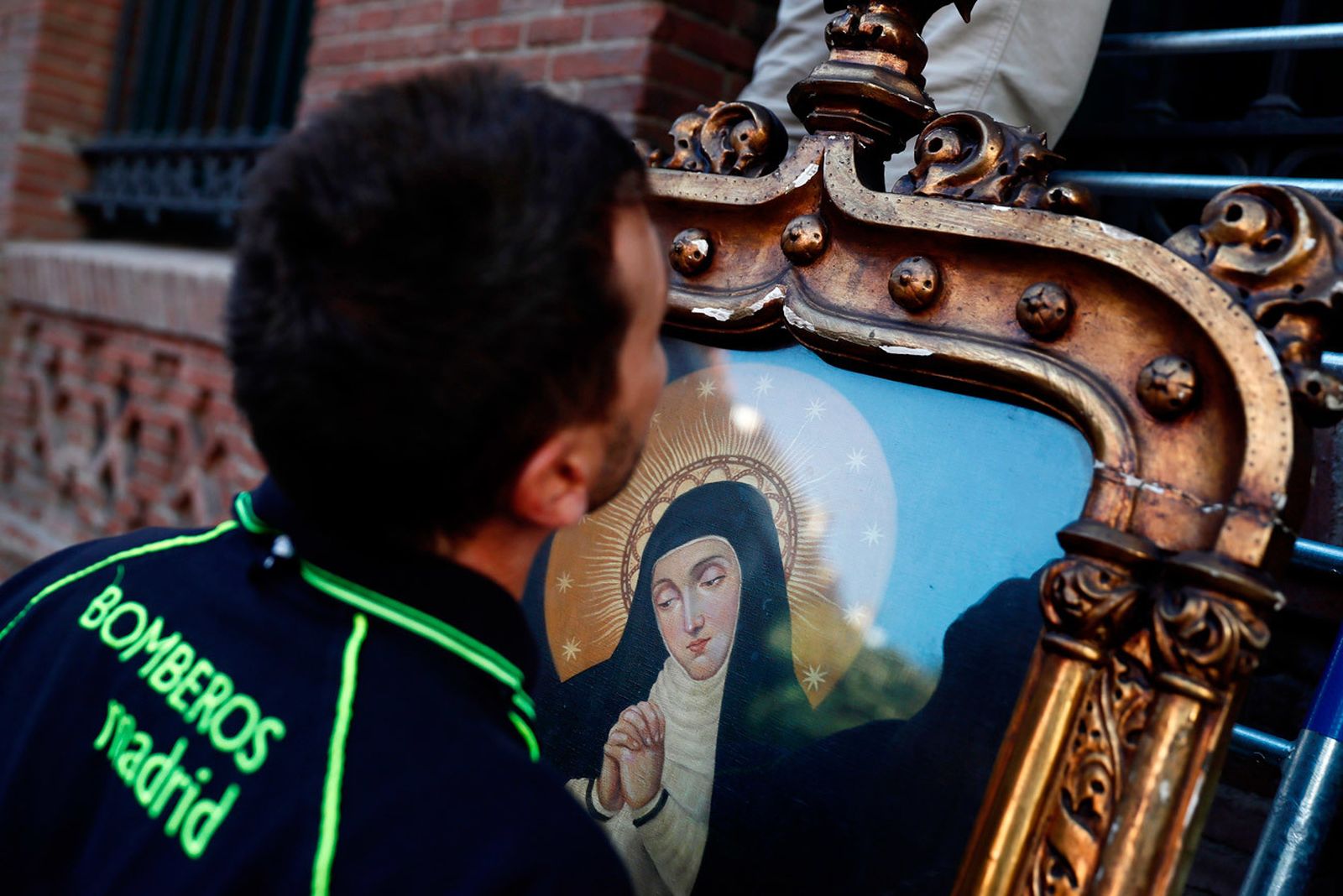 Un Bomberos y chulapos en los preparativos para el tradicional descendimiento del cuadro de la Virgen de La Paloma