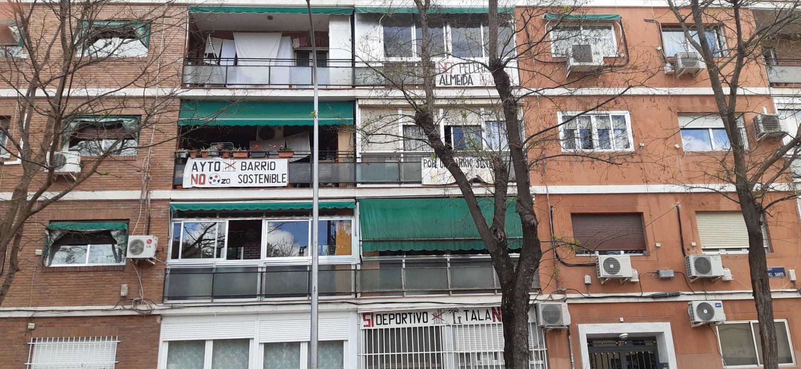 Carteles en la fachada de un edificio frente al centro comercial Art Decó, en el Paseo de la Ermita del Santo