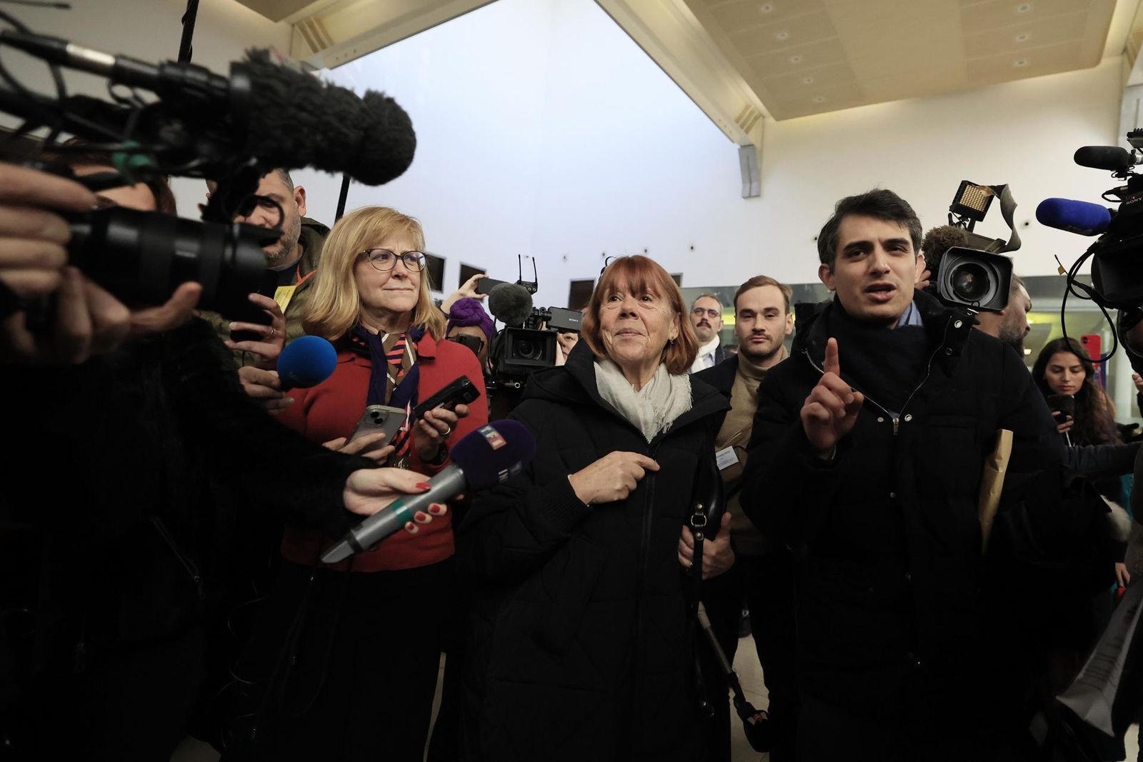 Gisele Pelicot , escoltada por su abogado Stephane Babonneau , sale del tribunal penal.