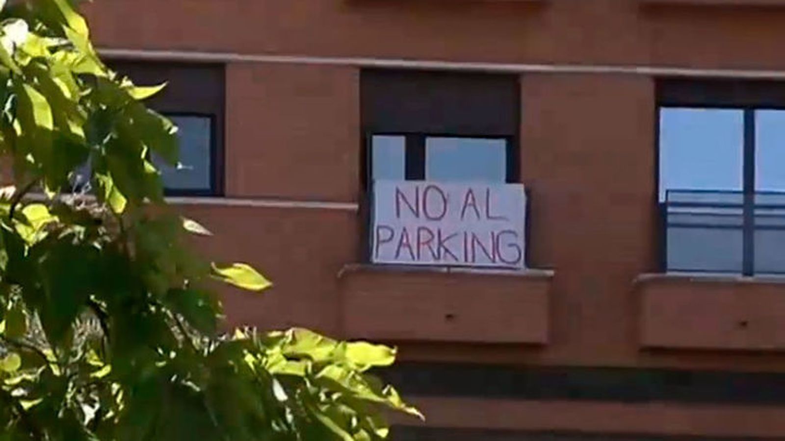 Cartel en una ventana en contra del aparcamiento