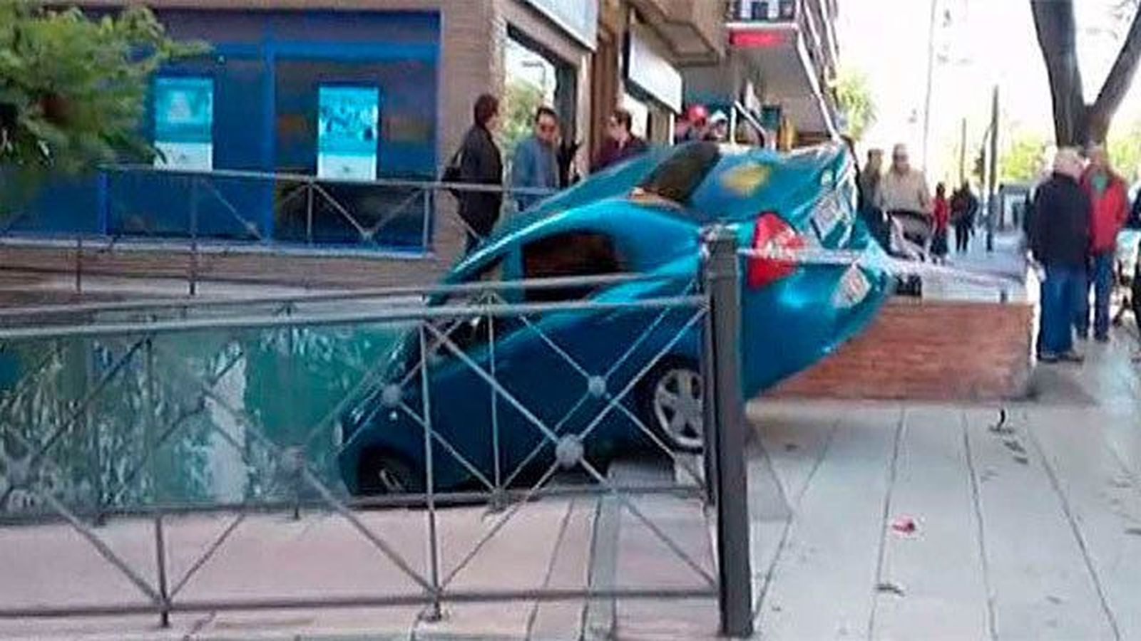 Un coche en las escaleras y otro sobre el quitamiedos