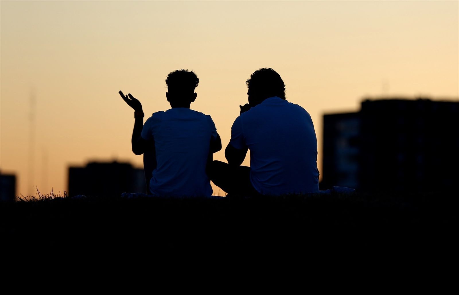 Dos personas conversan sentadas en el Cerro del Tío Pío