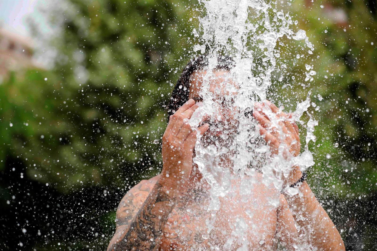 En Valencia los termómetros rozarán los 40 grados... a lo que hay que añadir la humedad que convertirá el ambiente en asfixiante. Ante esta situación, lo mejor es refrescarse con agua, como hace este joven.