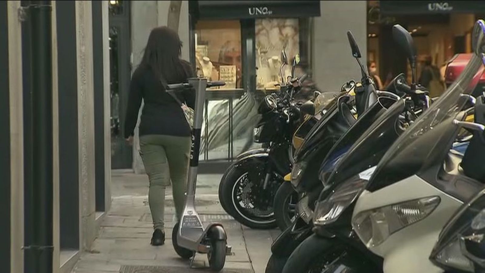 Patinetes y motos mal aparcados en la acera