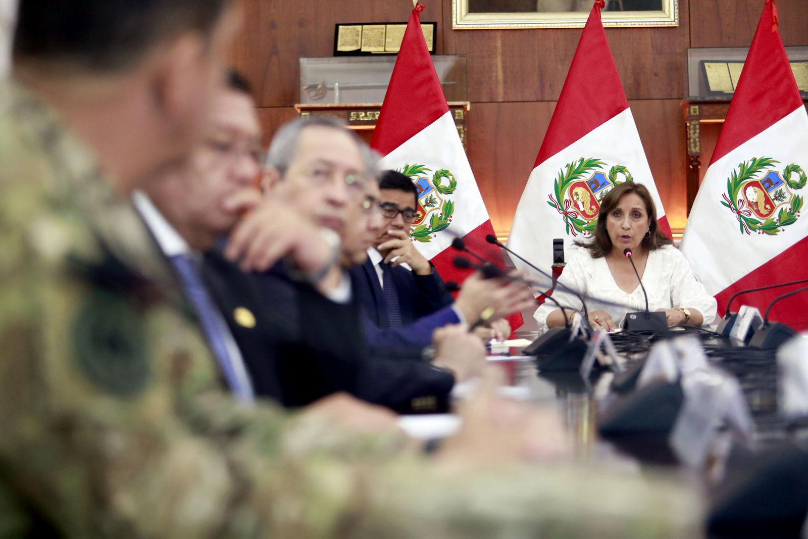 Fotografía cedida por la Presidencia del Perú que muestra a la mandataria Dina Boluarte (d) mientras habla en la reunión del Consejo de Estado