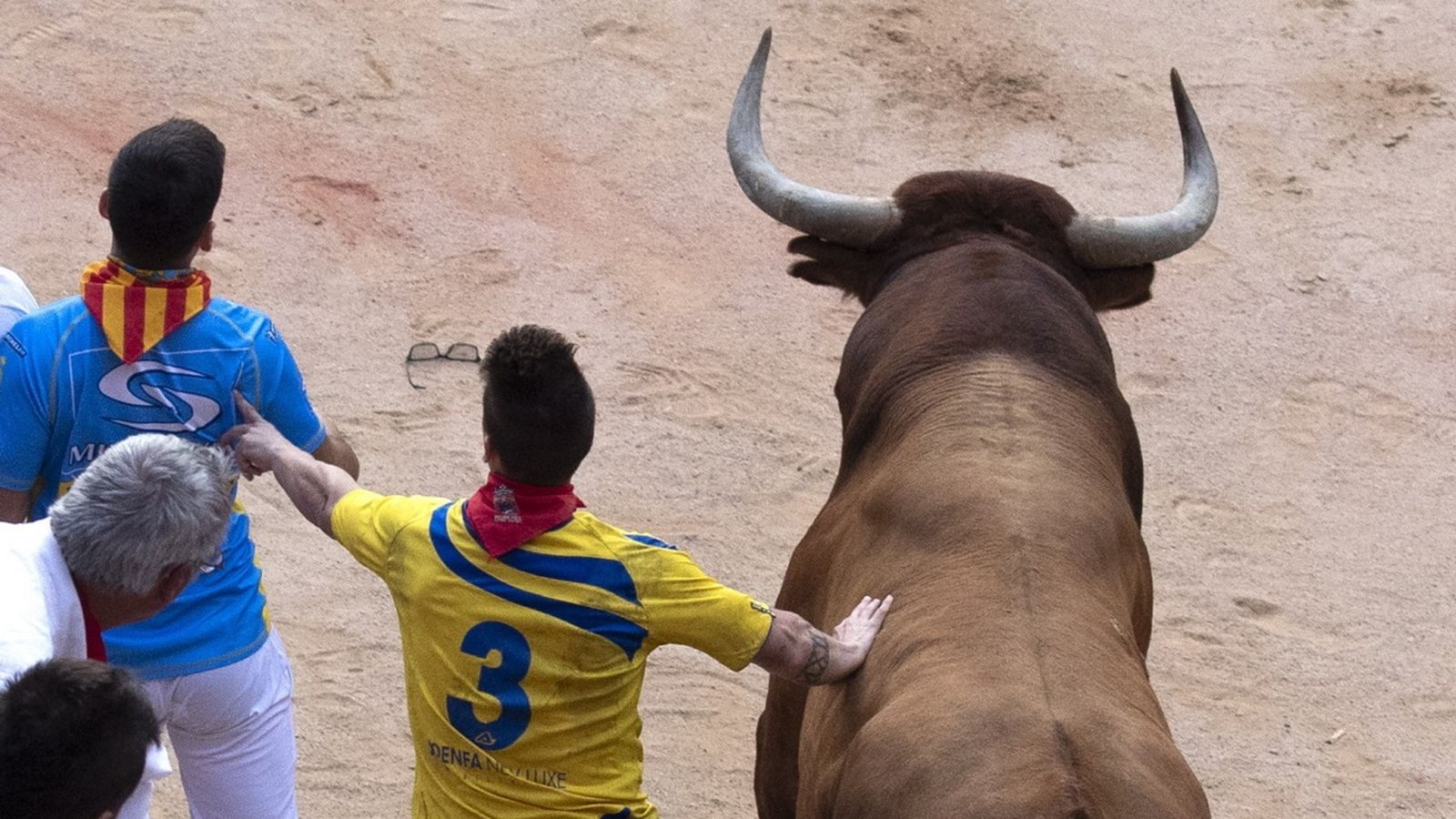 Dos corredores junto a un astado en San Fermín