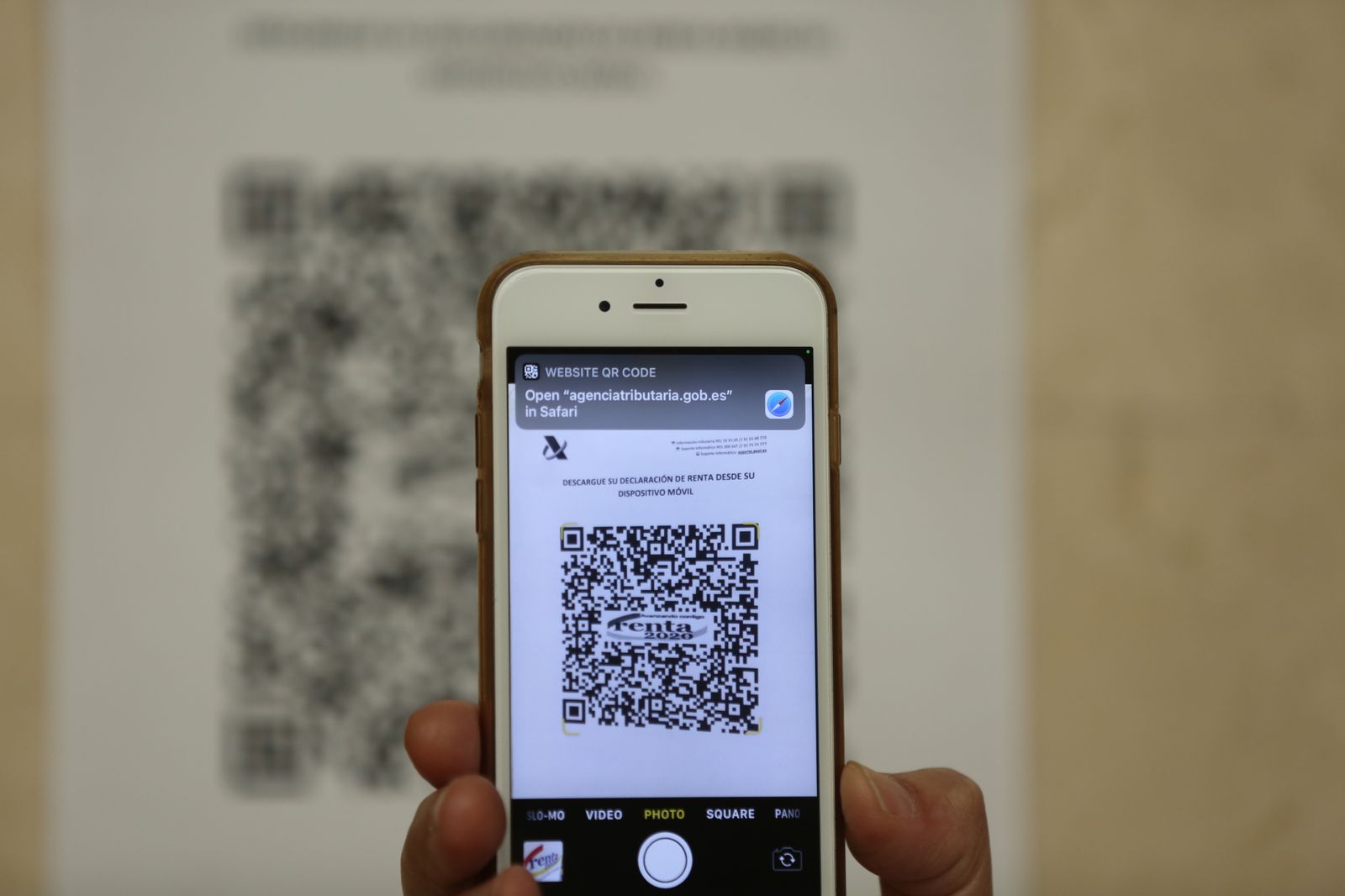 Una persona muestra un código QR con el que acceder a la declaración de la Renta