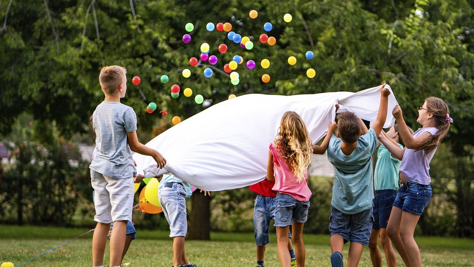 Un grupo de niños mantean bolas de colores