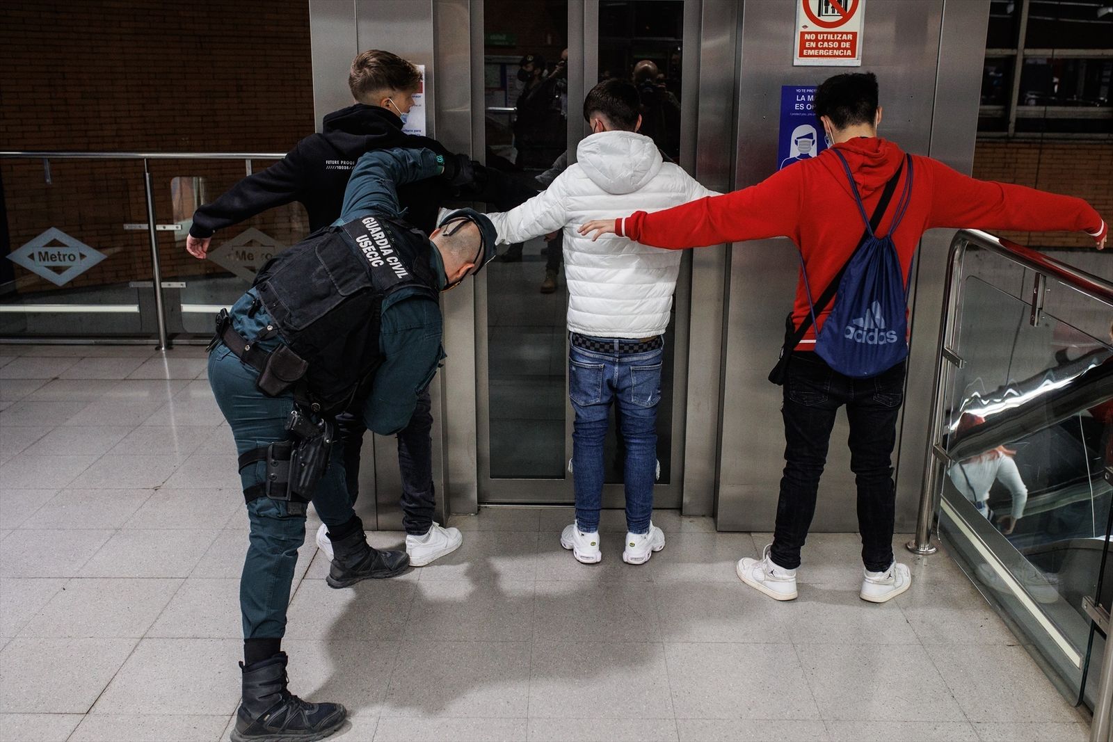 Dos agentes de la Guardia Civil cachean a dos jóvenes en un control para prevenir la violencia entre bandas juveniles, en la estación de metro de Arganda del Rey