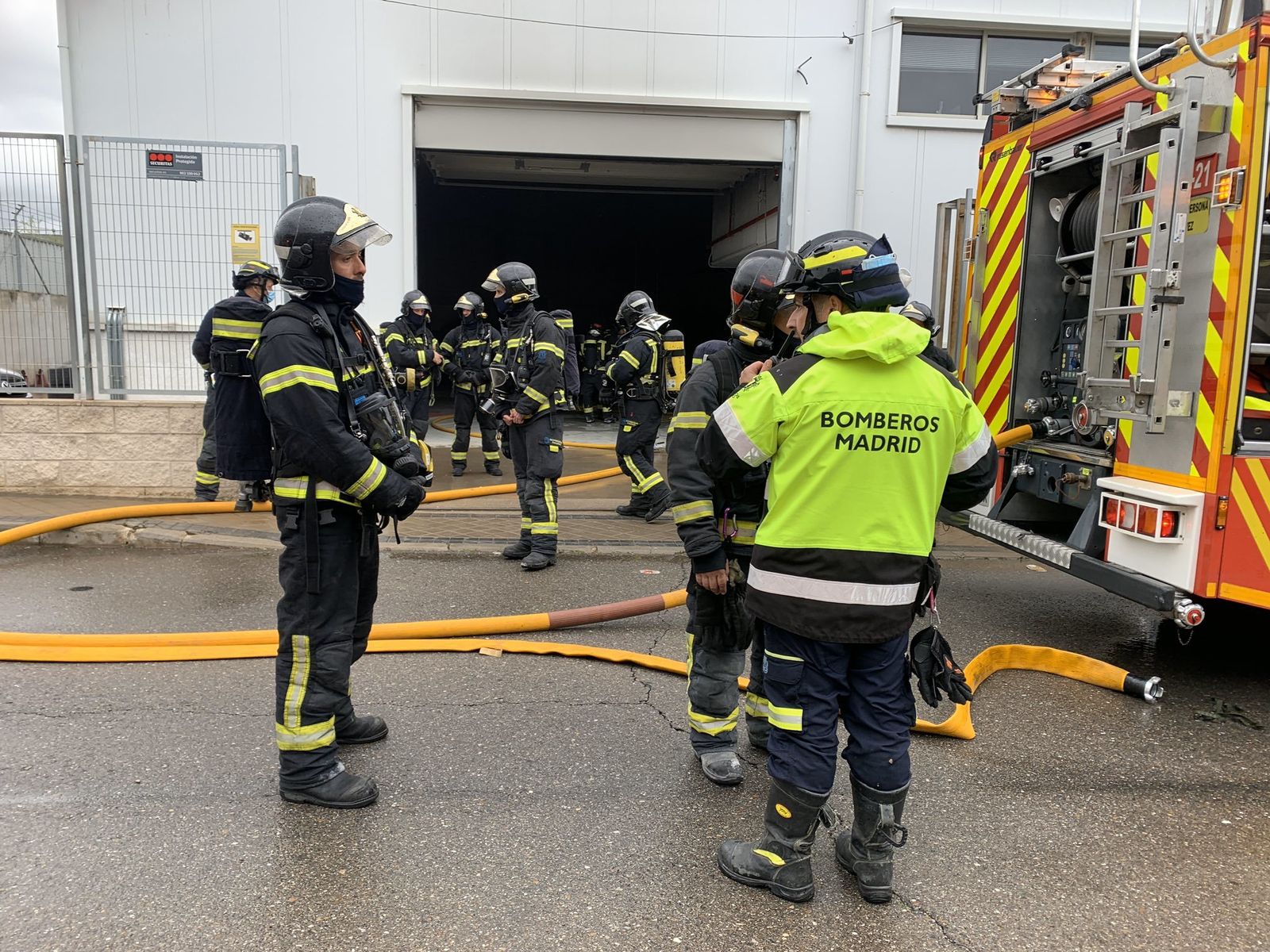 Bomberos en el exterior de la nave incendiada de Barajas